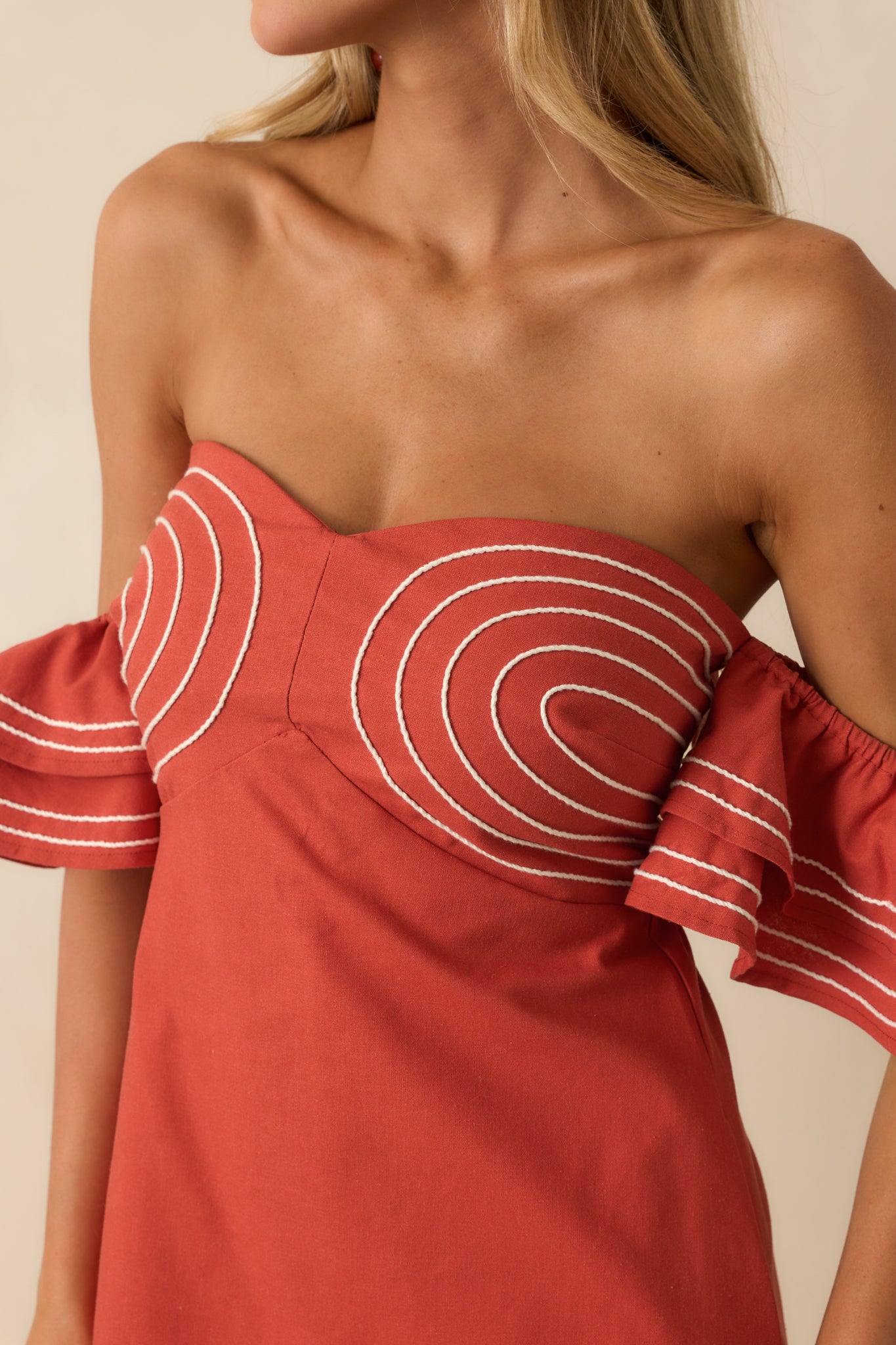 A close-up detail of the white rope trim and flutter sleeve fabric texture.