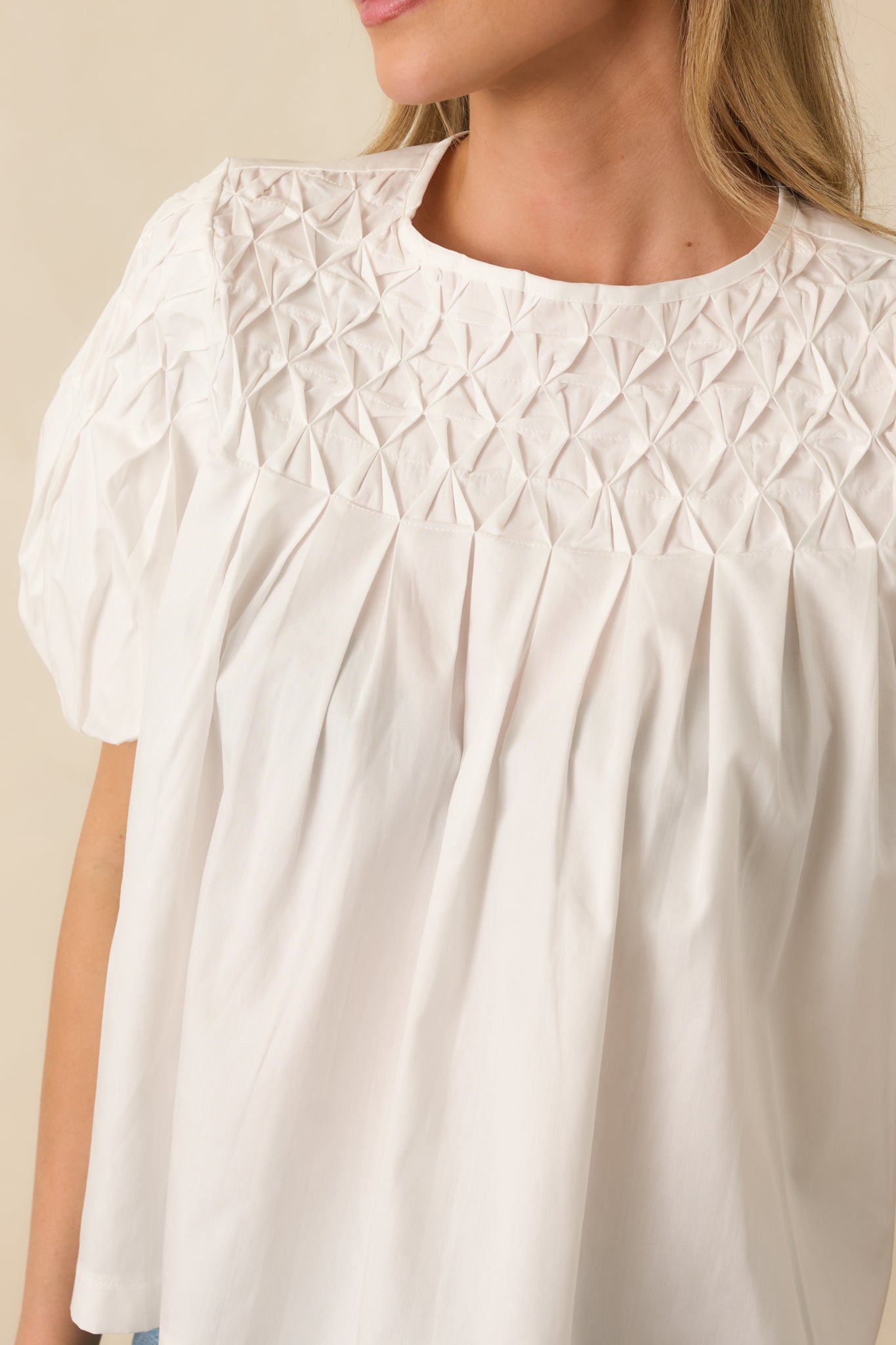 Close-up detail of the white top showcasing the lattice smocked yoke texture and soft fabric finish.
