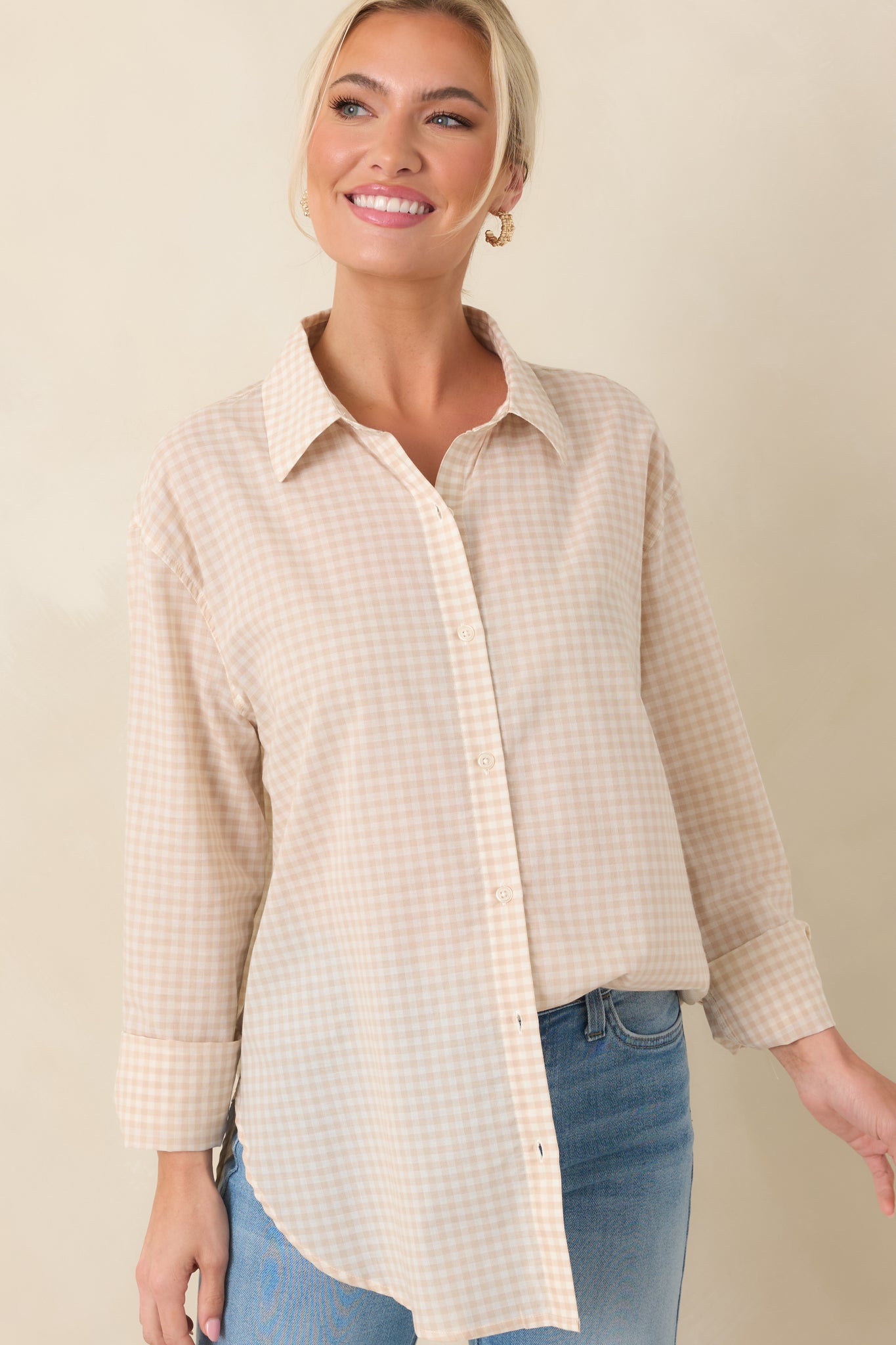 Detailed crop of beige gingham button-up with a slightly curved hem and classic styling.