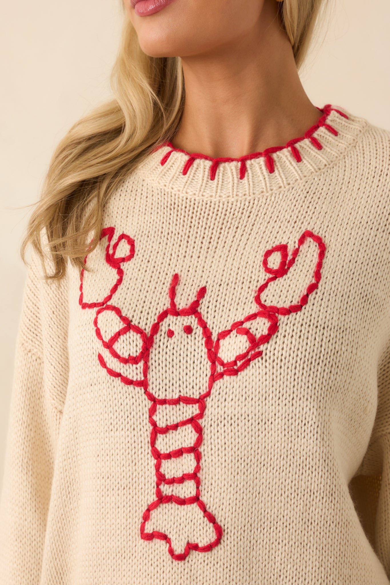 Detailed knit view of the lobster motif, showing the textured stitching in red.