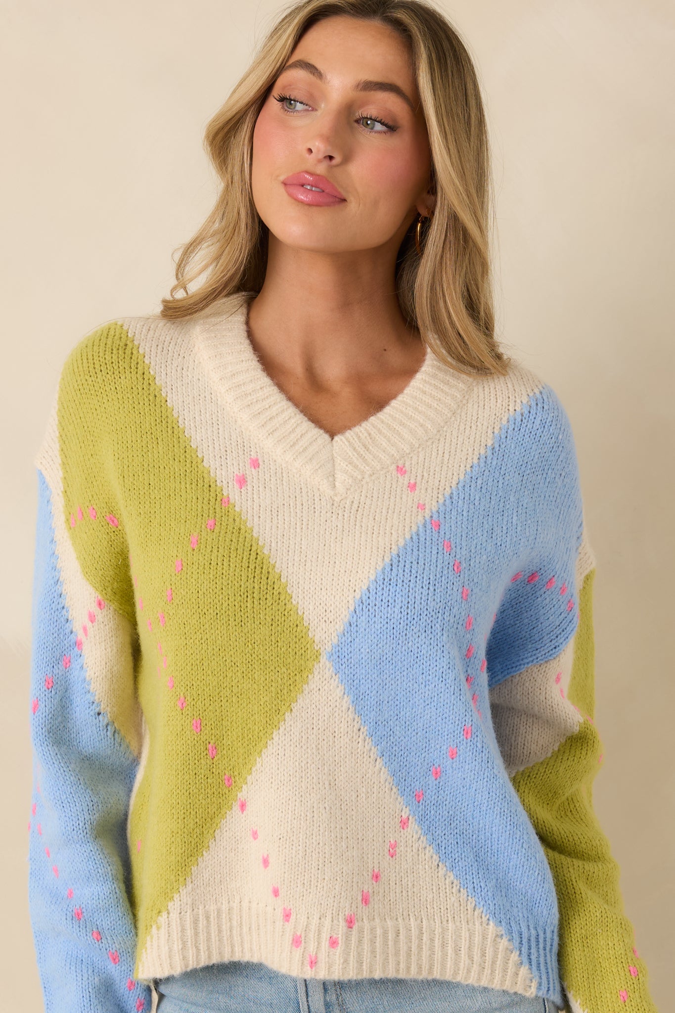 Detailed look at argyle knit sleeve cuff in green and blue with ribbed texture.