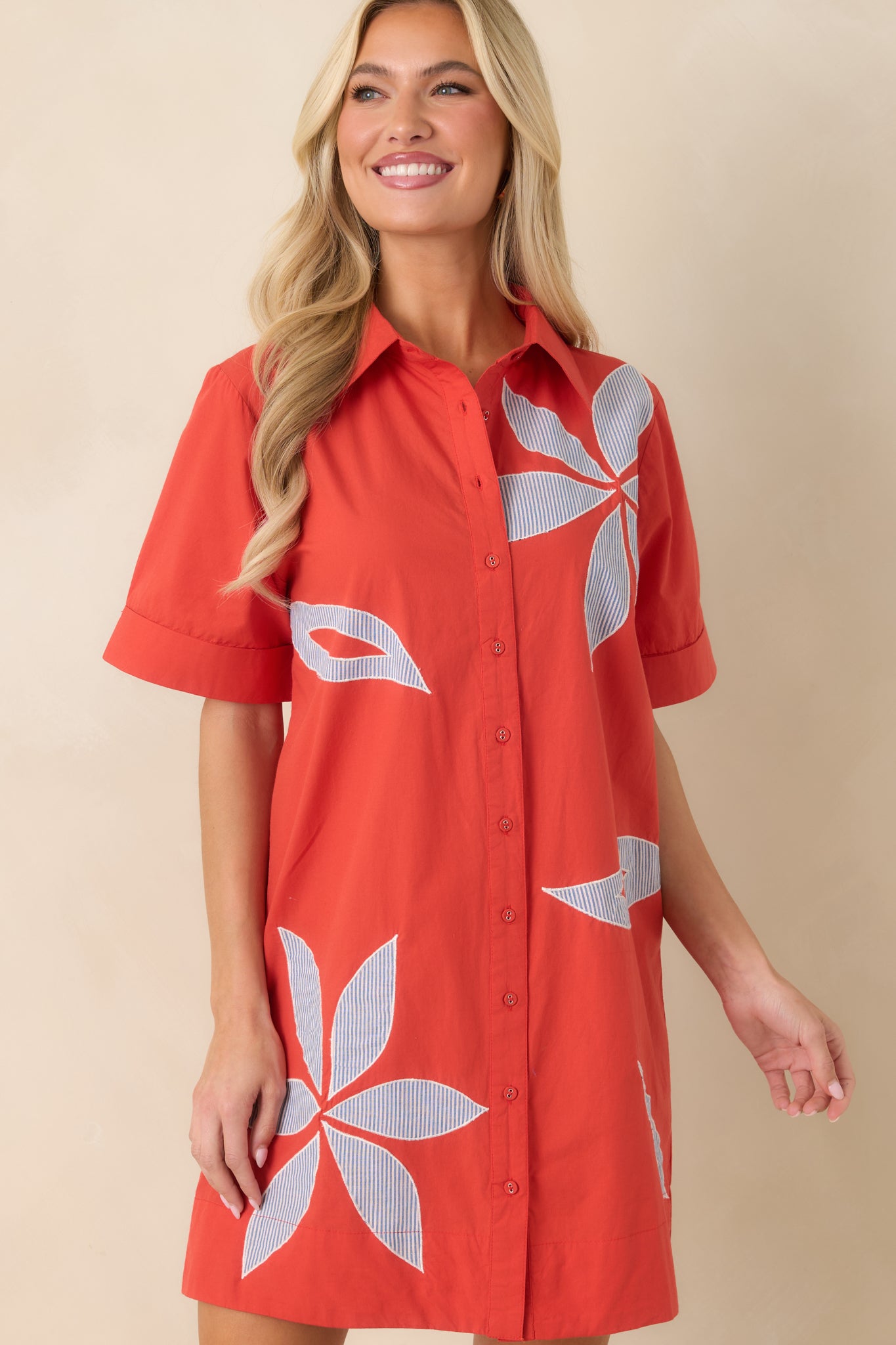 Detailed look at striped fabric with floral appliqué elements and classic button-front styling.