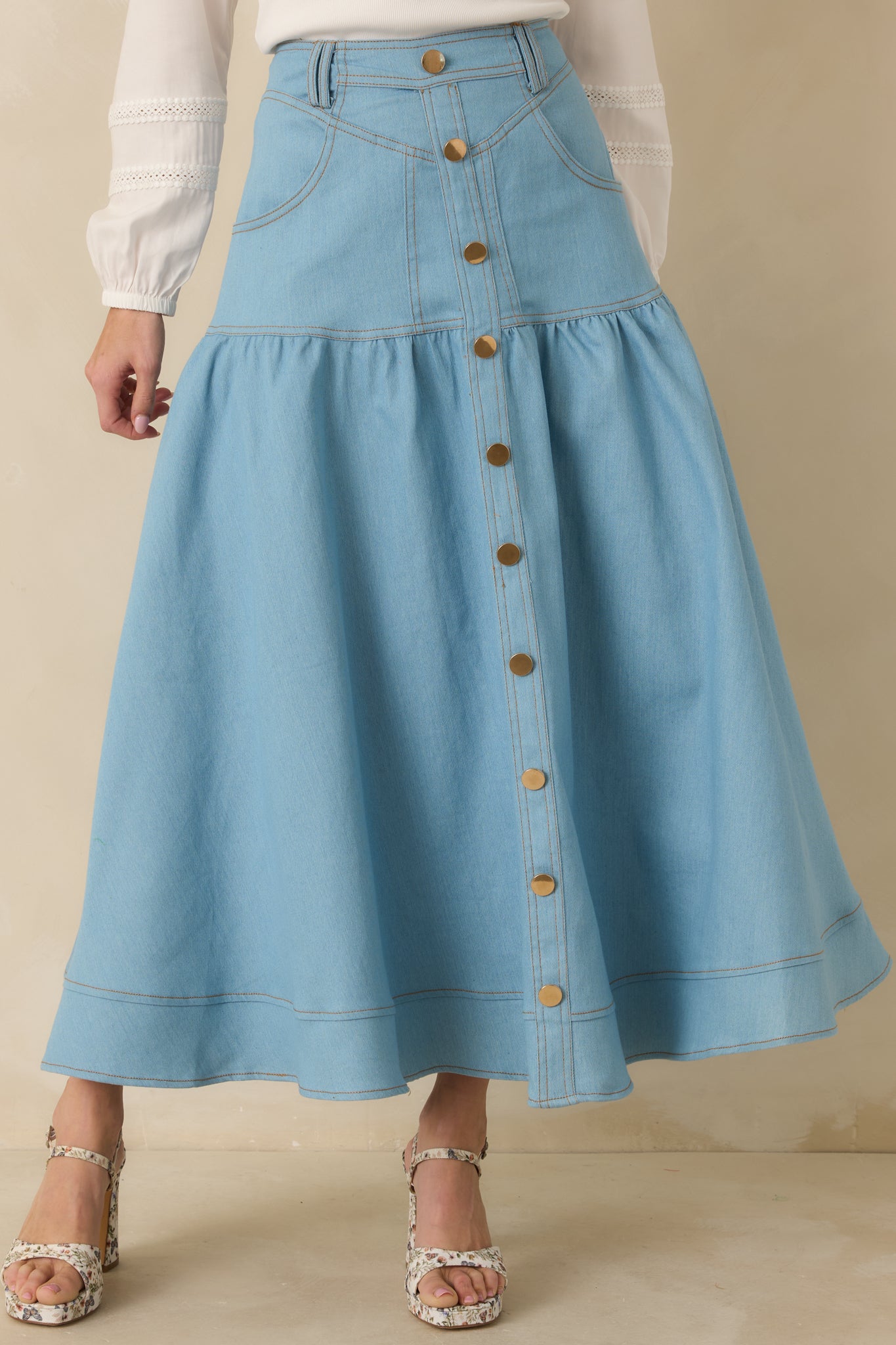 Detailed look at the tiered construction and contrast topstitching in light wash denim.