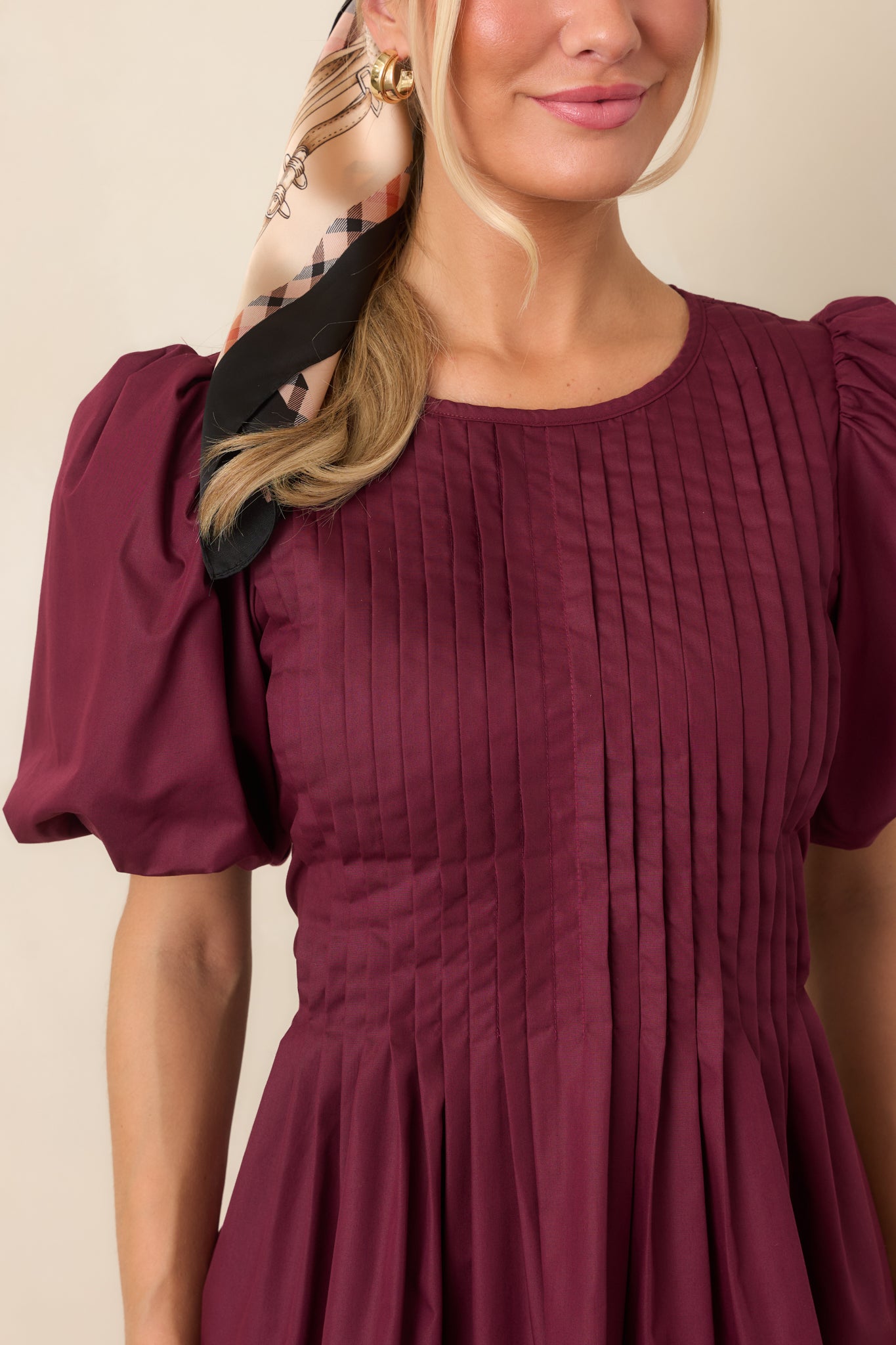 Close-up of the mini dress highlighting the intricate pintucking across the bodice and the dimensional texture created by the fine stitched pleats.