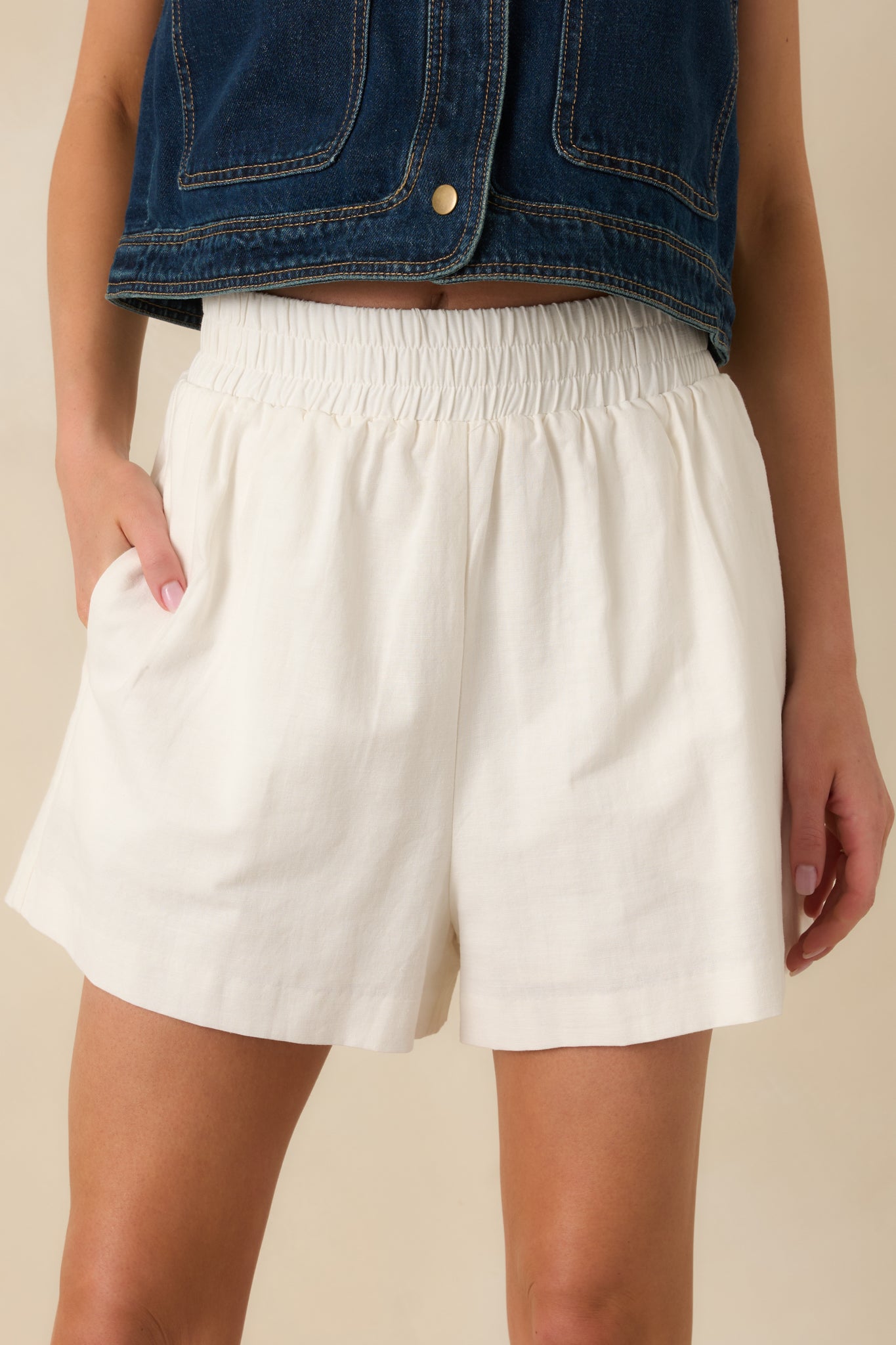 Detailed cropped front view of ivory shorts highlighting lightweight fabric and pull-on style.