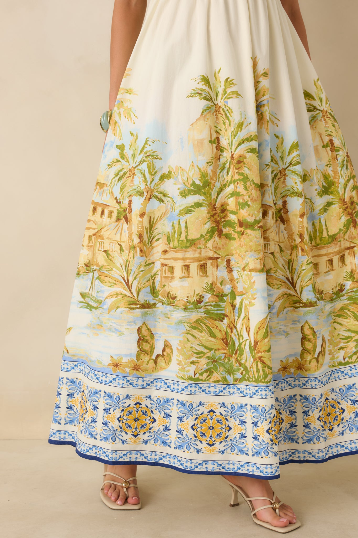 Detailed view of multicolor scenic print with contrast border on ivory maxi dress.