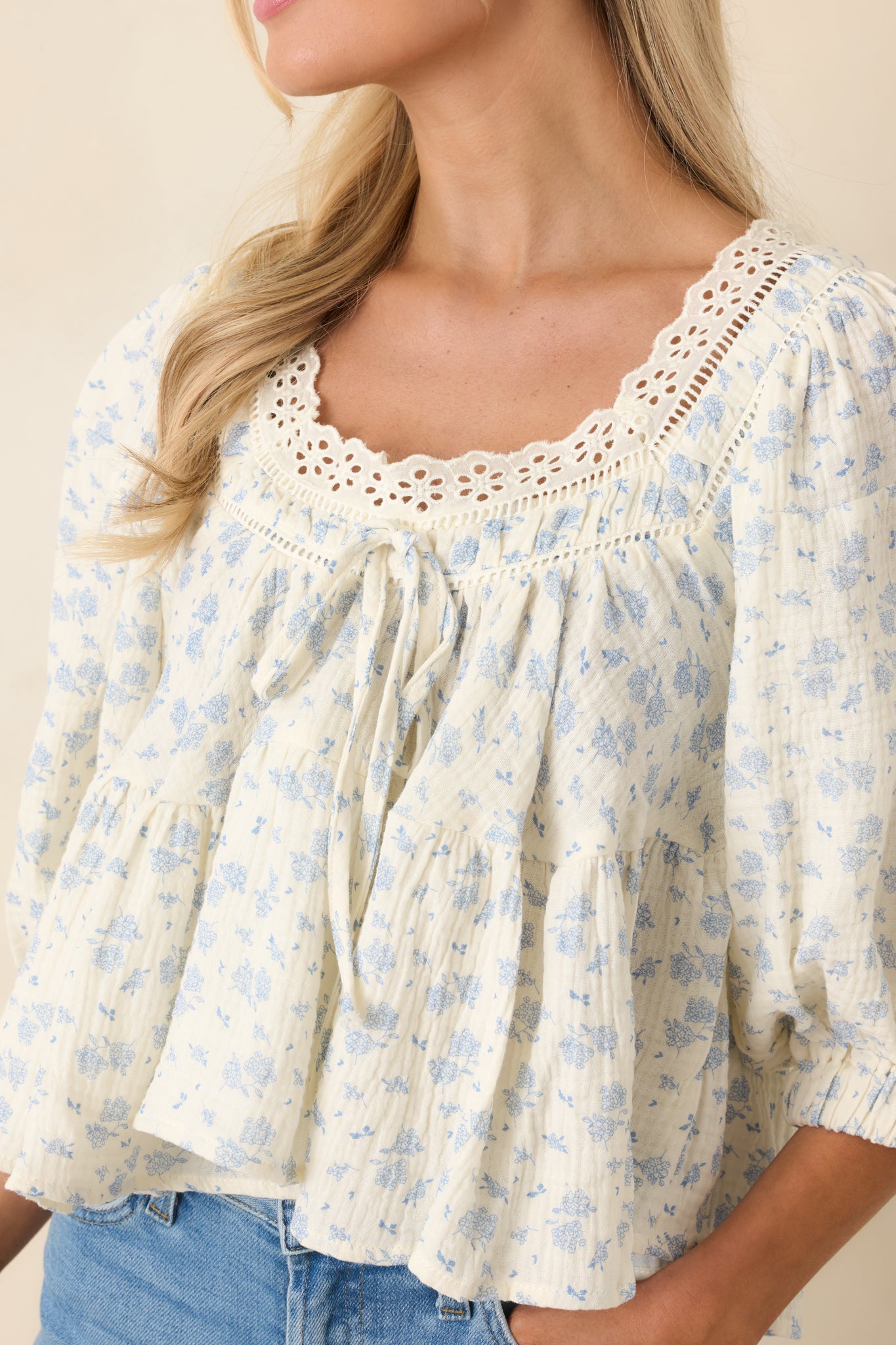 Detailed view of scalloped eyelet neckline, tiered bodice, and dainty floral print.