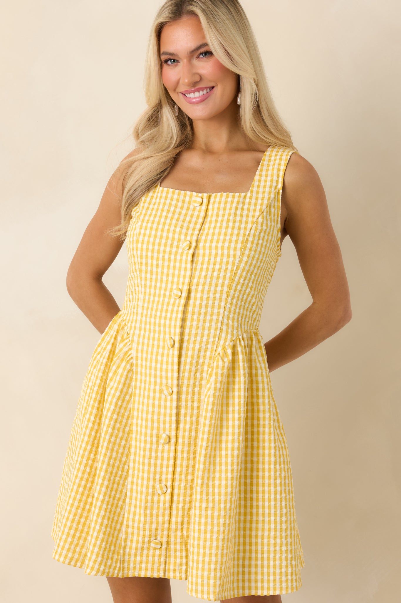 Detailed view of yellow gingham dress with breezy fit and structured front.