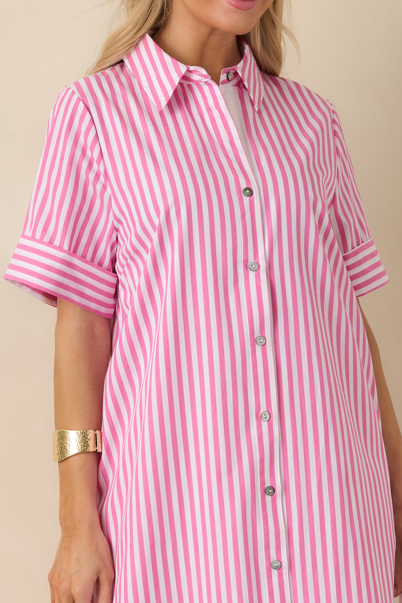Detailed view of shirt dress fabric showing stripes, collared neckline, and button-front closure.