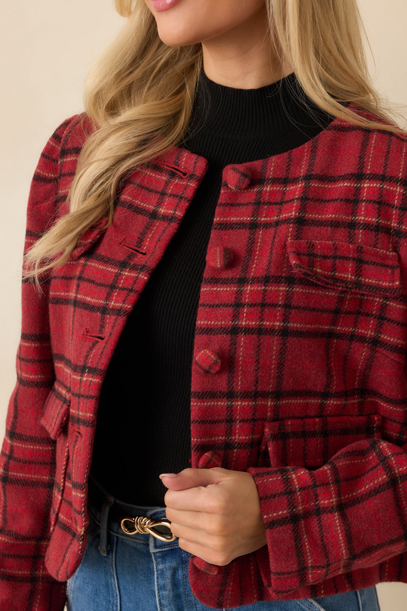 Detailed view of soft woven texture, buttons, and flap pocket on red jacket.