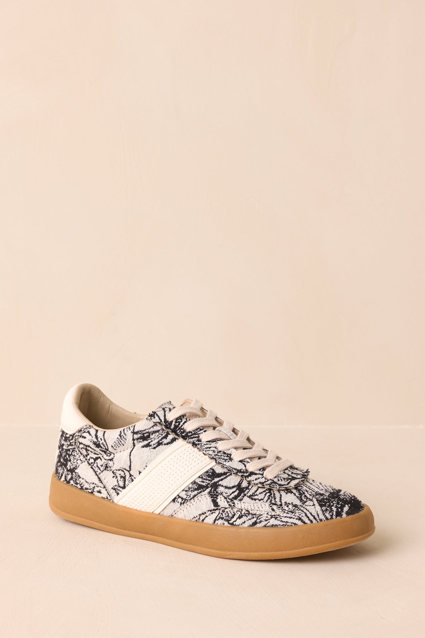 Diagonal front view showing the rounded toe, lace-up design, and floral canvas upper.