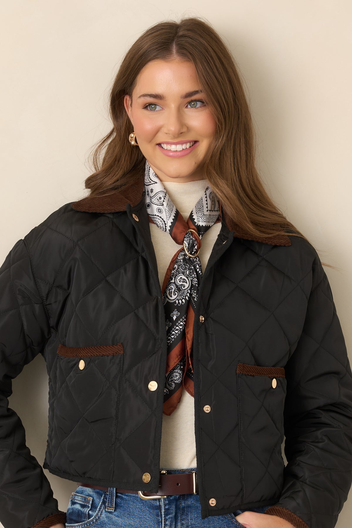 Diamond-stitched jacket highlighting the contrasting brown collar and coordinating black binding along the bottom edge.