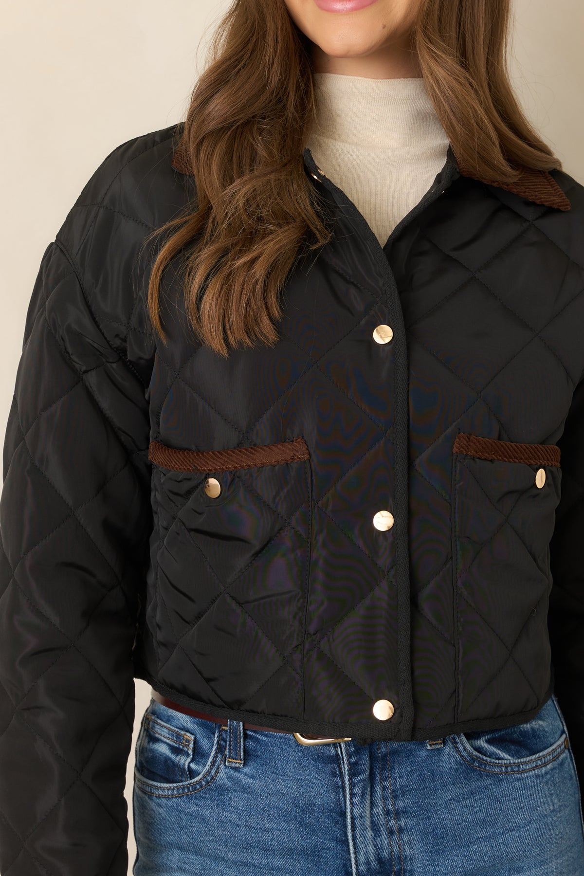 Diamond-stitched jacket detail highlighting the brown collar, snap-front closure, and contrast-trimmed patch pocket.