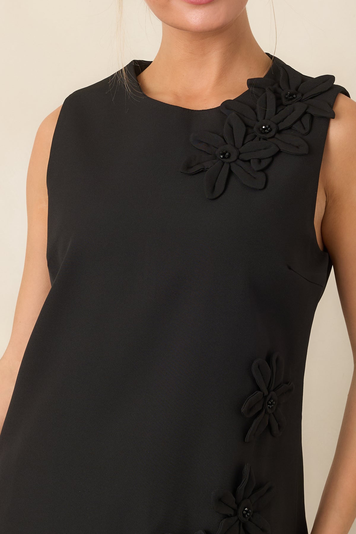 Close detail of the dimensional floral appliqués and glossy black beaded centers.