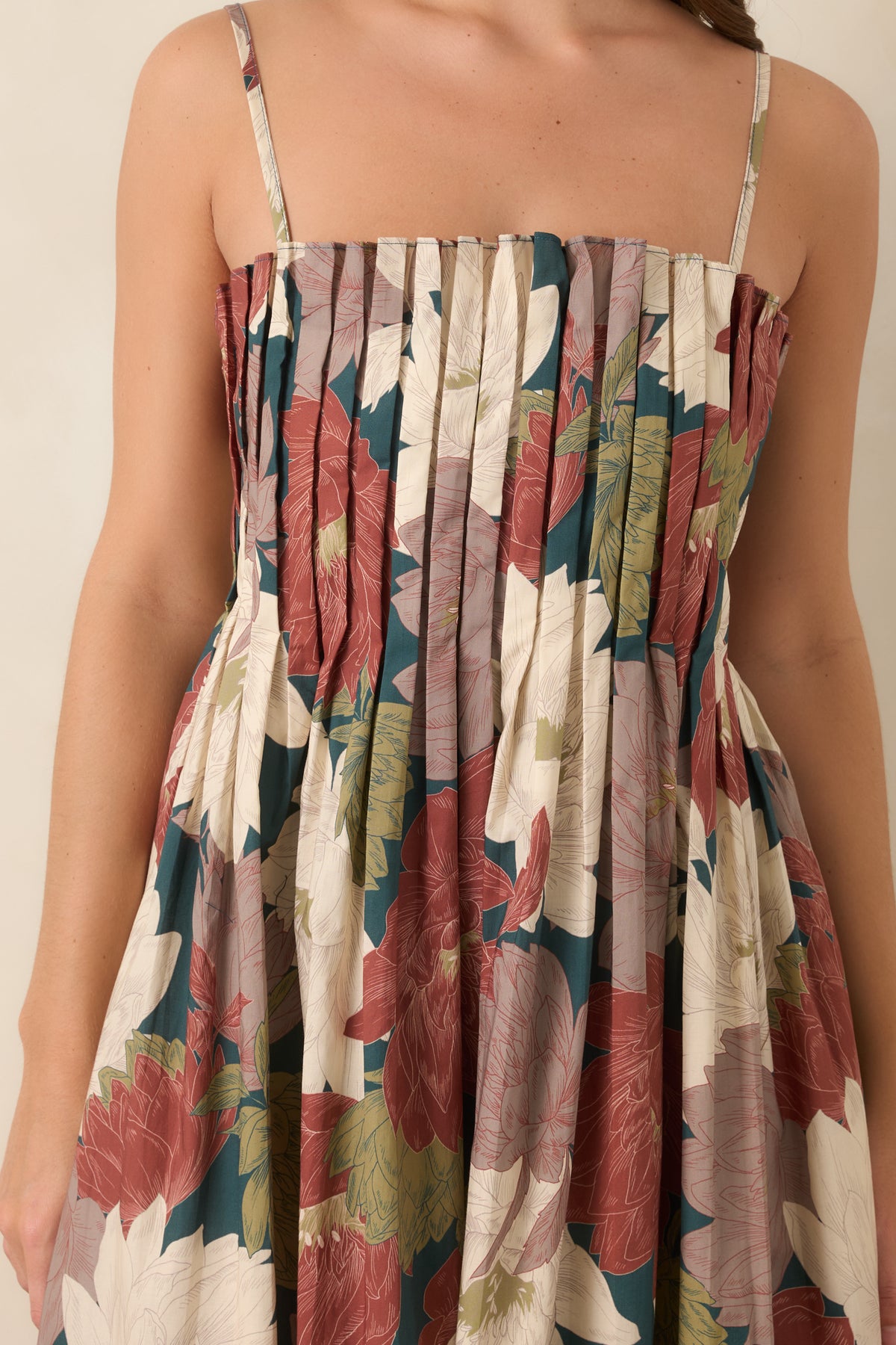 Close-up of the dimensional pleating and oversized floral print across the cotton bodice.
