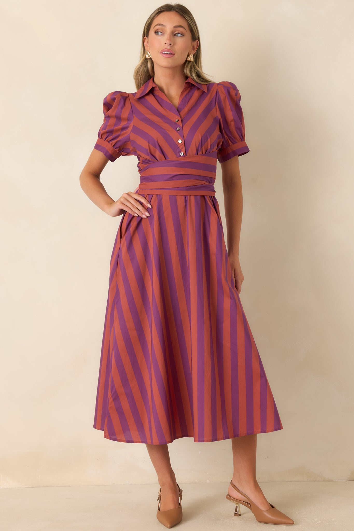 Striped cotton midi dress with directional panels across the bodice and waist, short puff sleeves, and a collared neckline. 