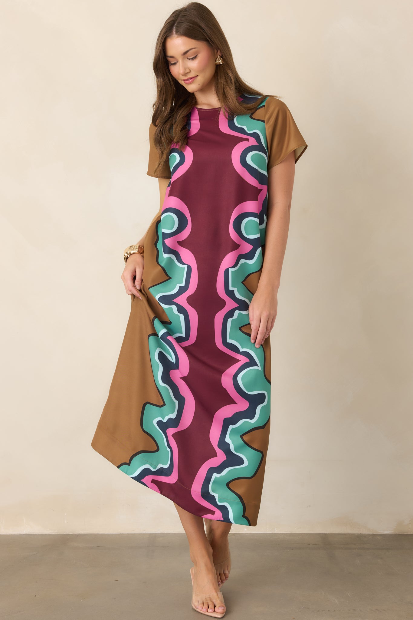 Serpentine-patterned maxi dress showcasing its softly draped silhouette, short sleeves, round neckline, and vibrant mix of burgundy, camel, seafoam, navy, light blue, and pink.