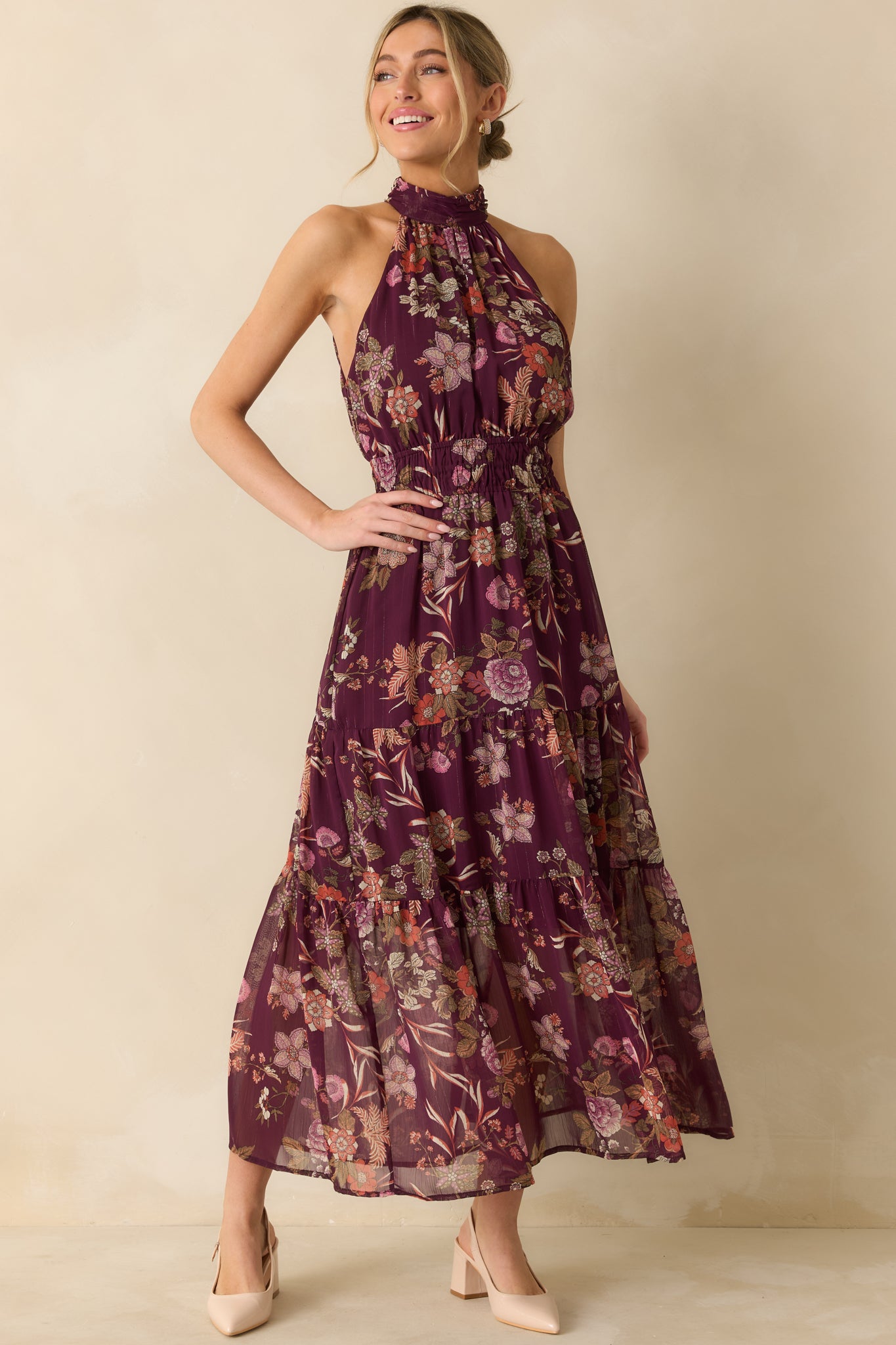 The dress displays its multi-color floral print, elastic waist shaping, and tiered layers for a polished look.