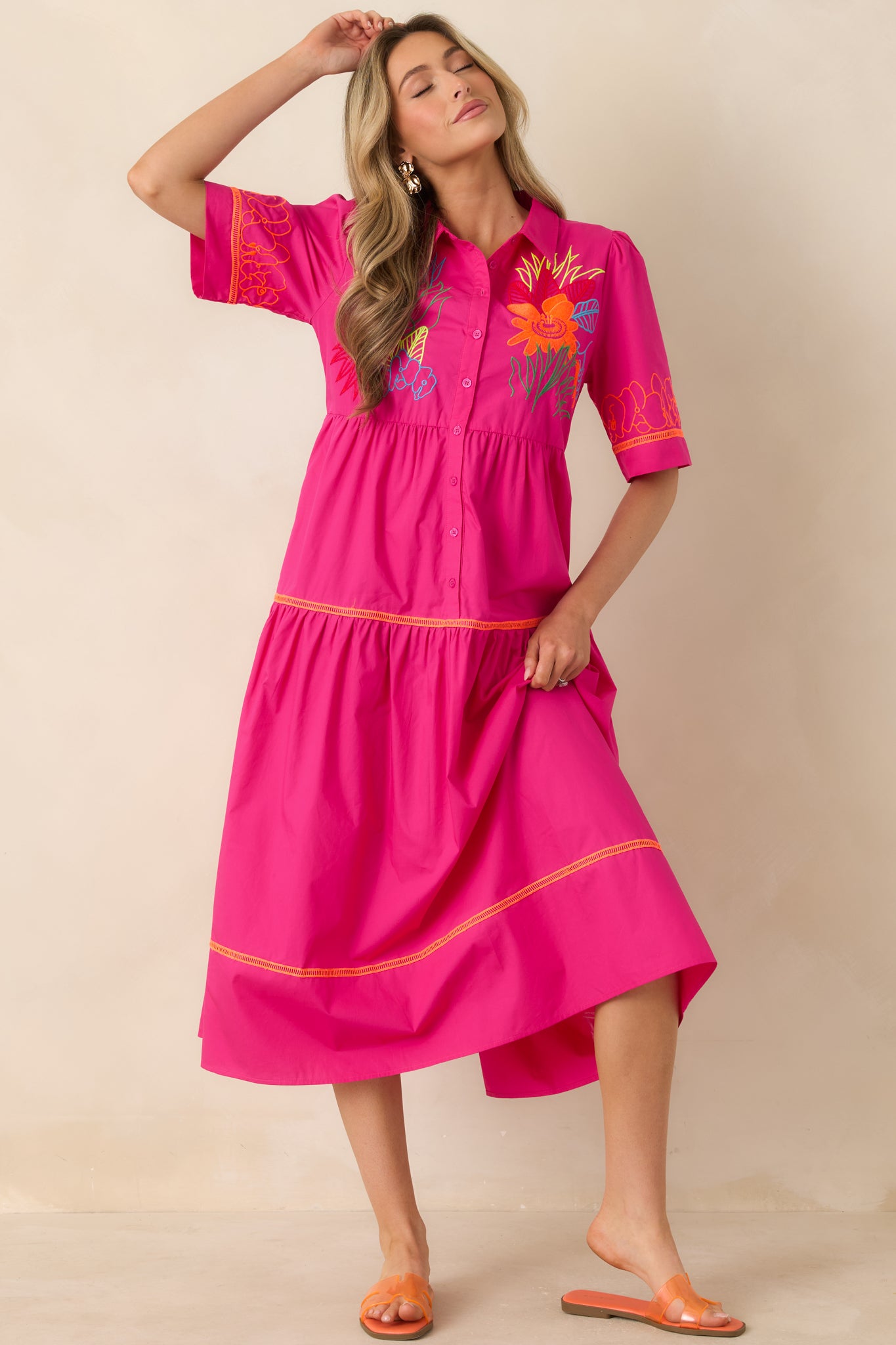 Dress with collared neckline, button-front detail, and tiered flowing silhouette.