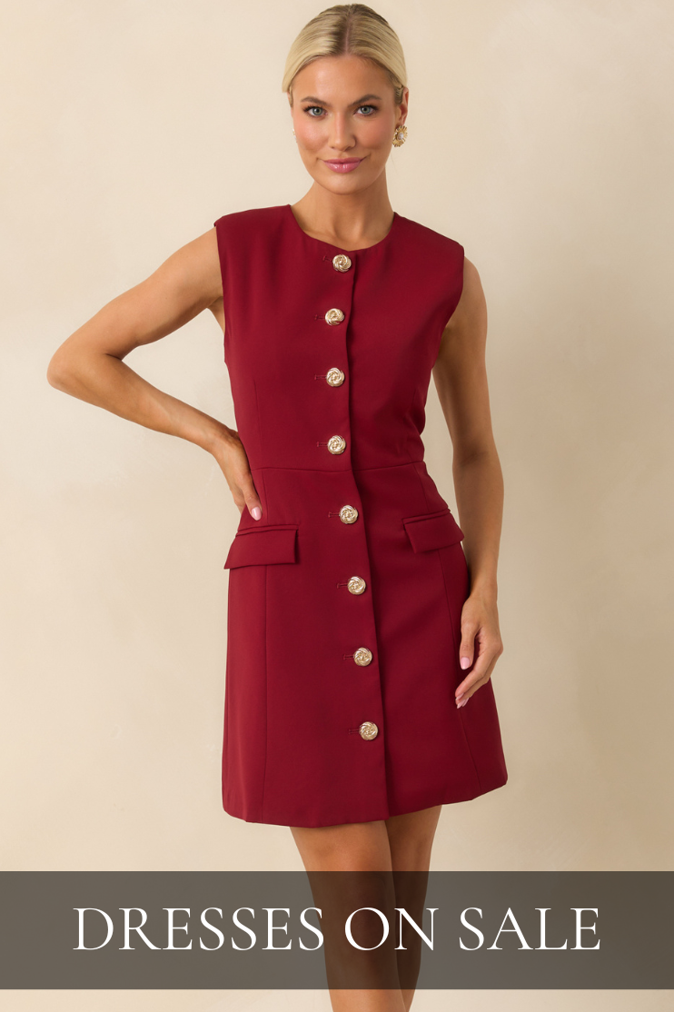 Woman wearing a sleeveless red button-front mini dress with gold details, showcasing chic and timeless styles from the Dresses on Sale collection.