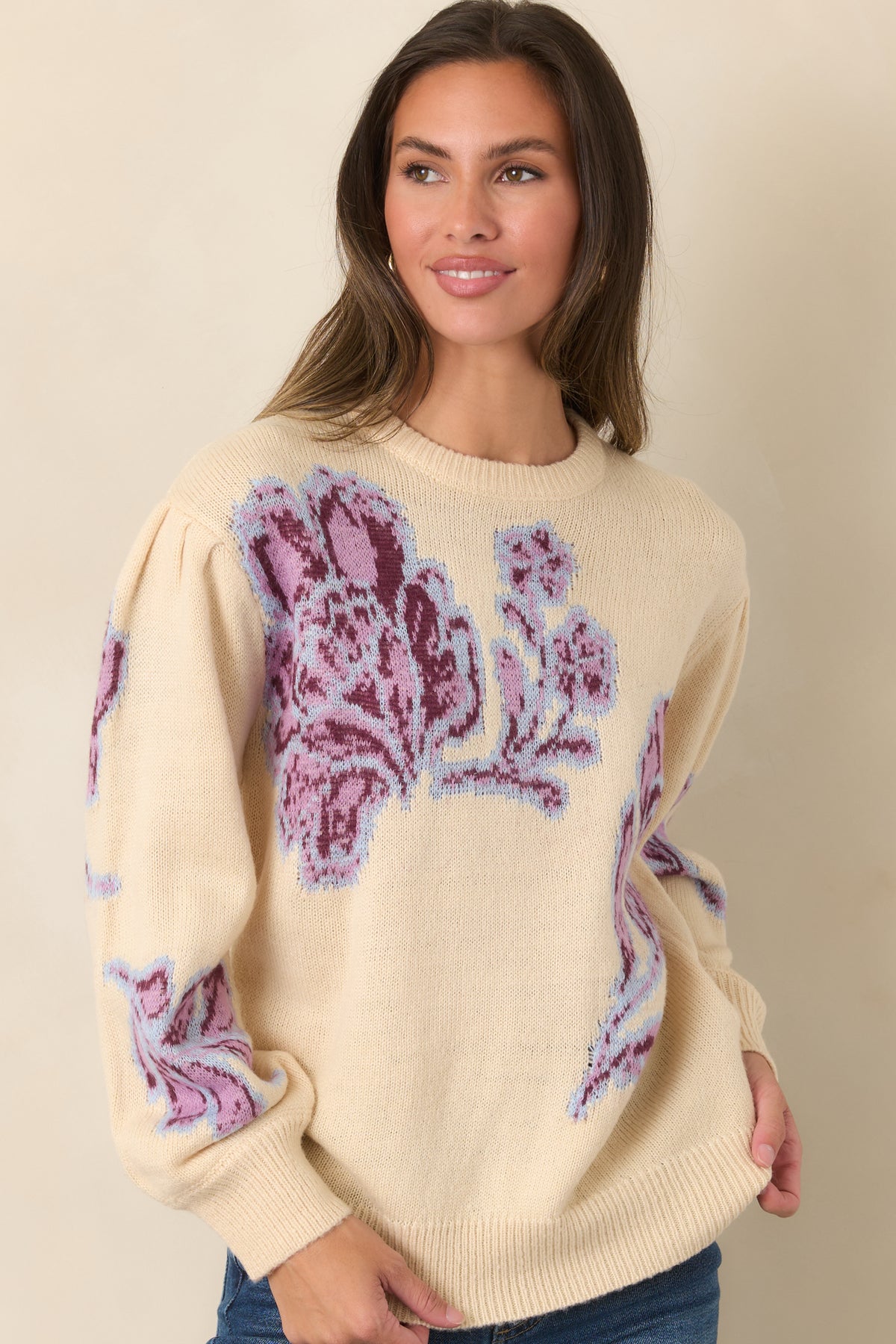 Dropped shoulders feature gentle gathers that add subtle volume to the long sleeves of the floral knit top.