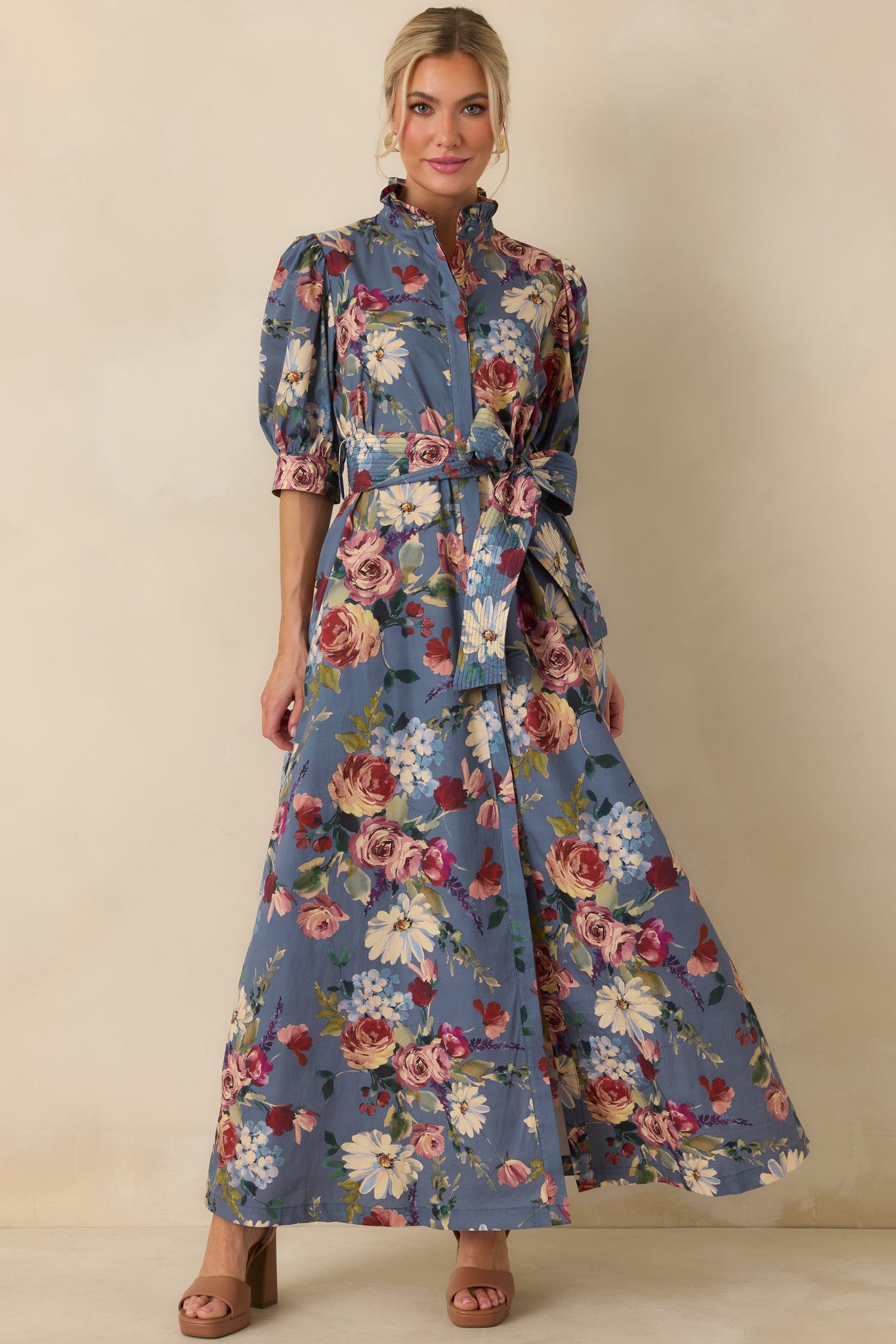 Dusty blue floral maxi dress featuring softly puffed sleeves, tailored cuffs, and a cinched waist.