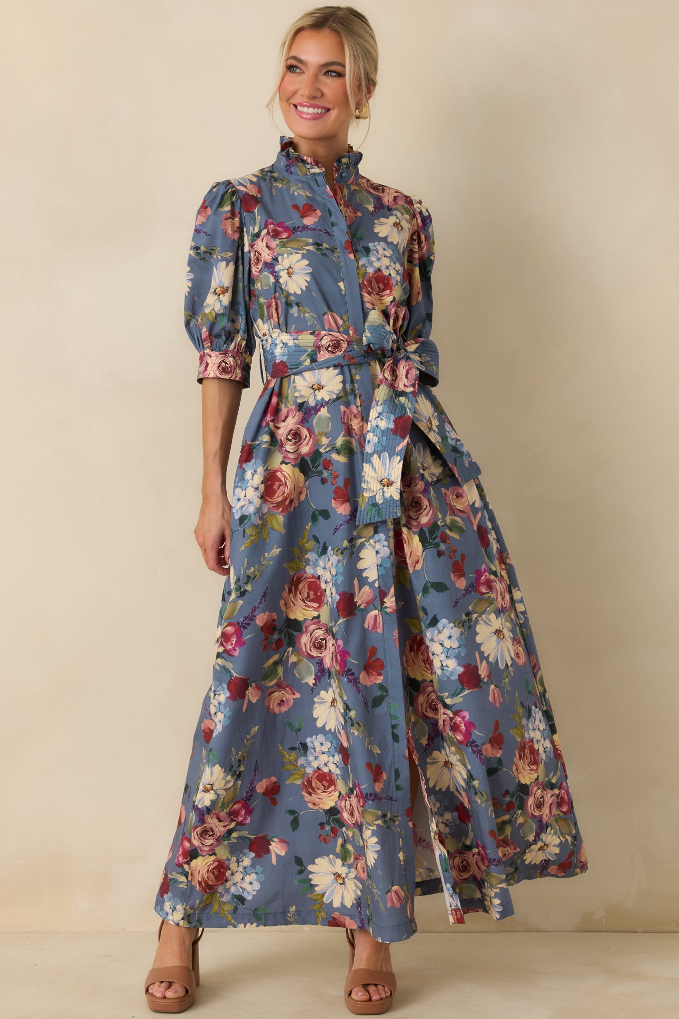 Dusty blue maxi dress showcasing its colorful floral pattern, self-tie waist belt, and flowing A-line silhouette.
