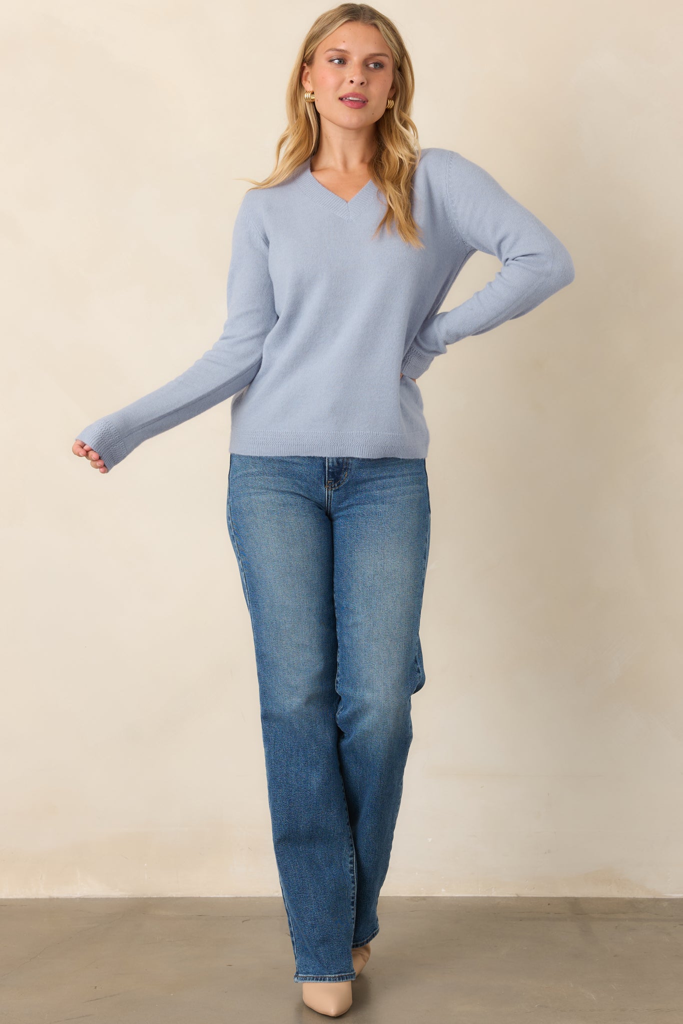 Muted dusty blue knit top featuring a flattering V-neckline, long sleeves, ribbed neckline and cuffs, and a relaxed silhouette.