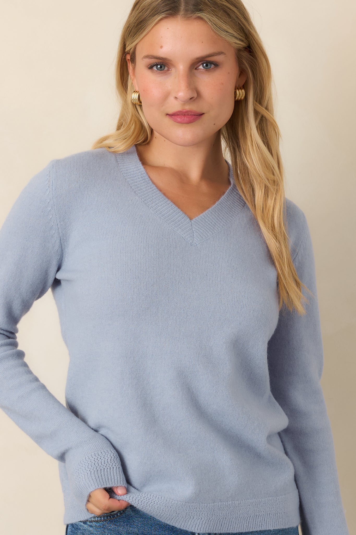 Soft wool-blend sweater featuring a relaxed neckline, smooth knit construction, and ribbed detailing along the V-neck and sleeve cuffs.