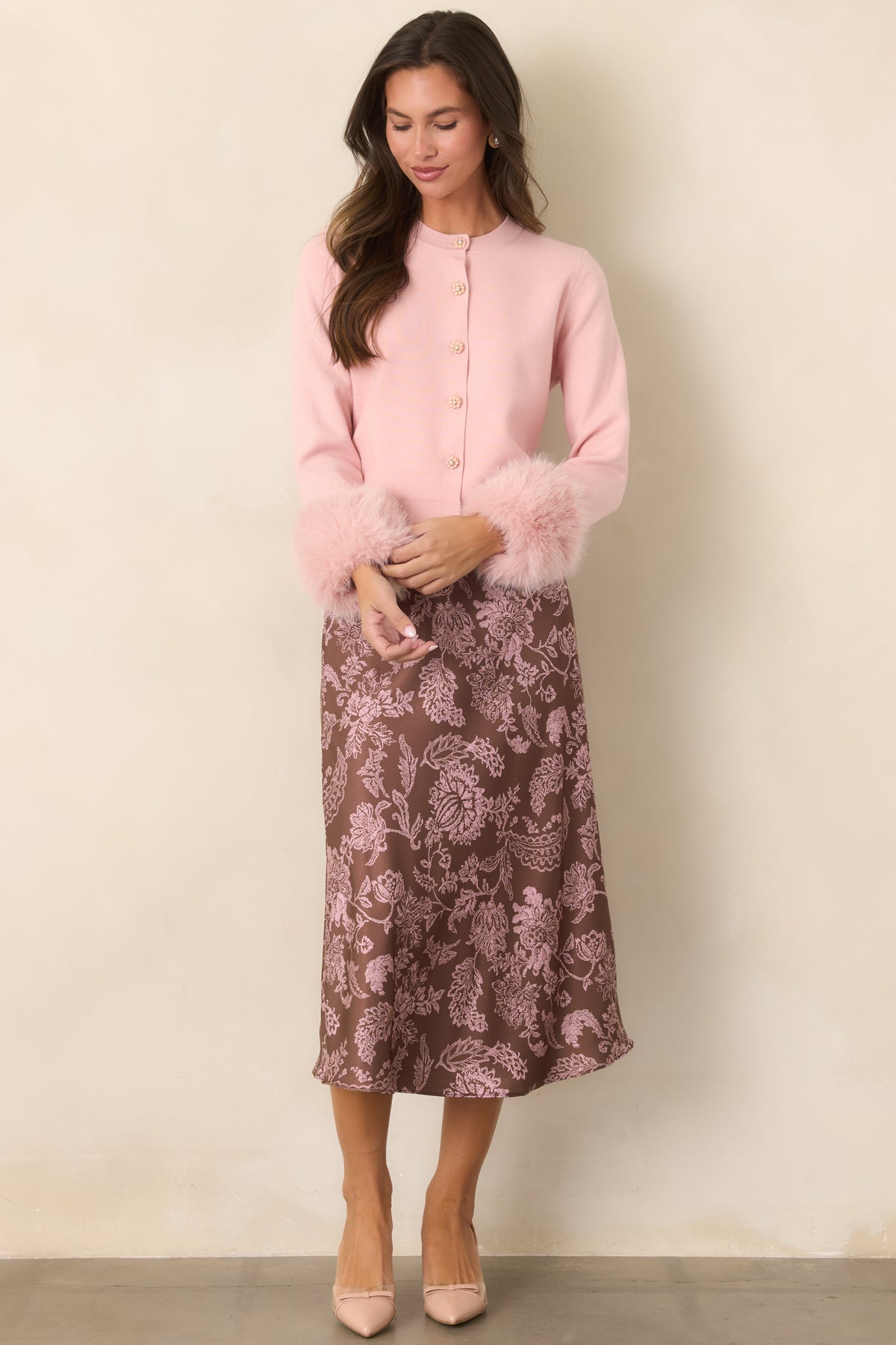 Dusty pink knit cardigan featuring plush faux fur cuffs and decorative floral buttons.