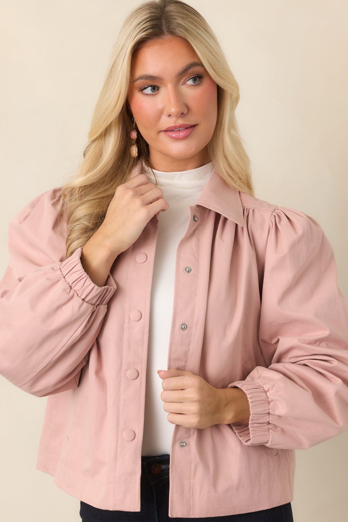 Dusty pink jacket highlighting the pointed collar and clean snap front closure.