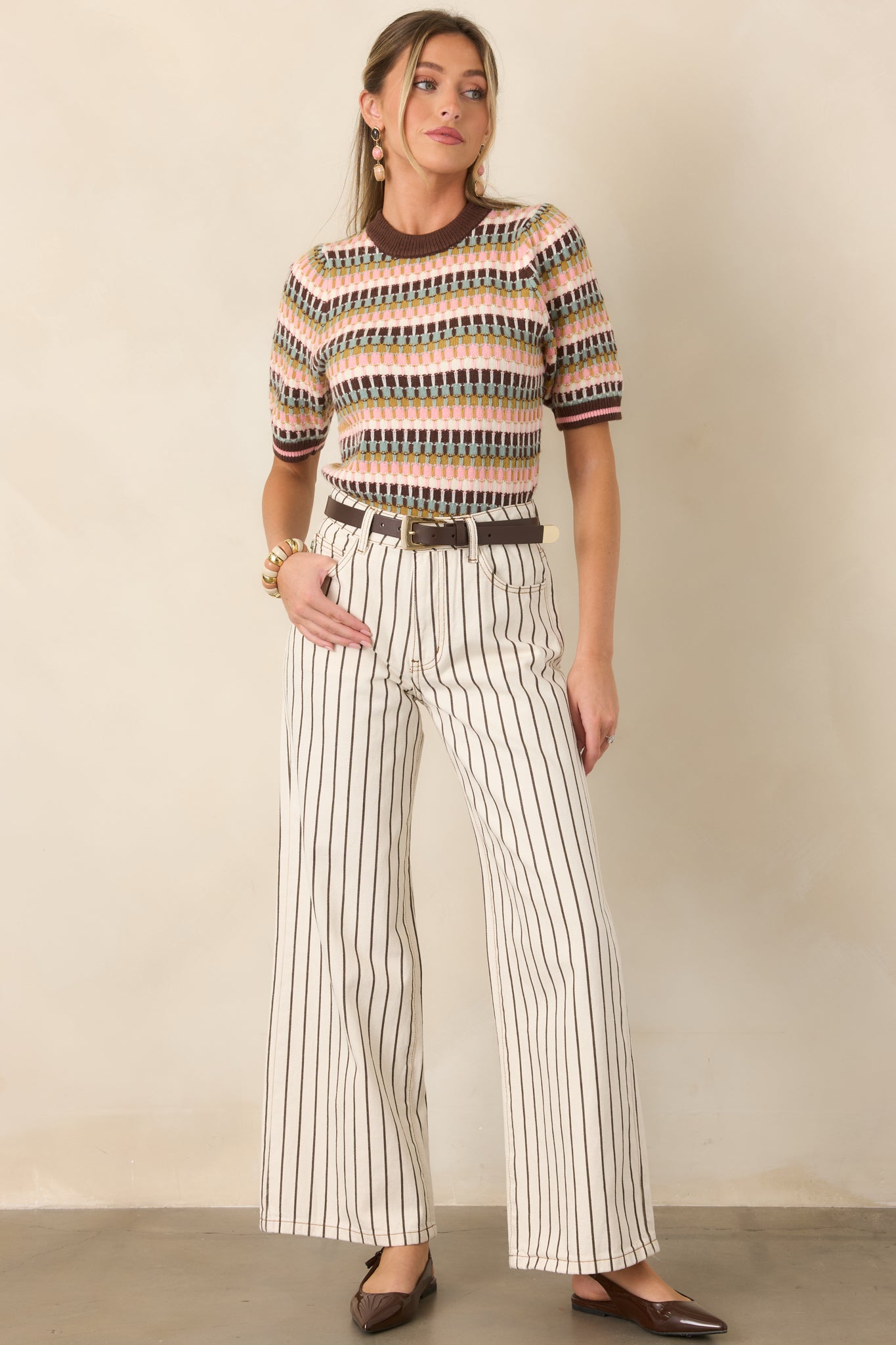 Earth-toned striped top combining textured brown, sage, olive, pink, and ivory bands with pink-accented ribbed trim for a polished finish.