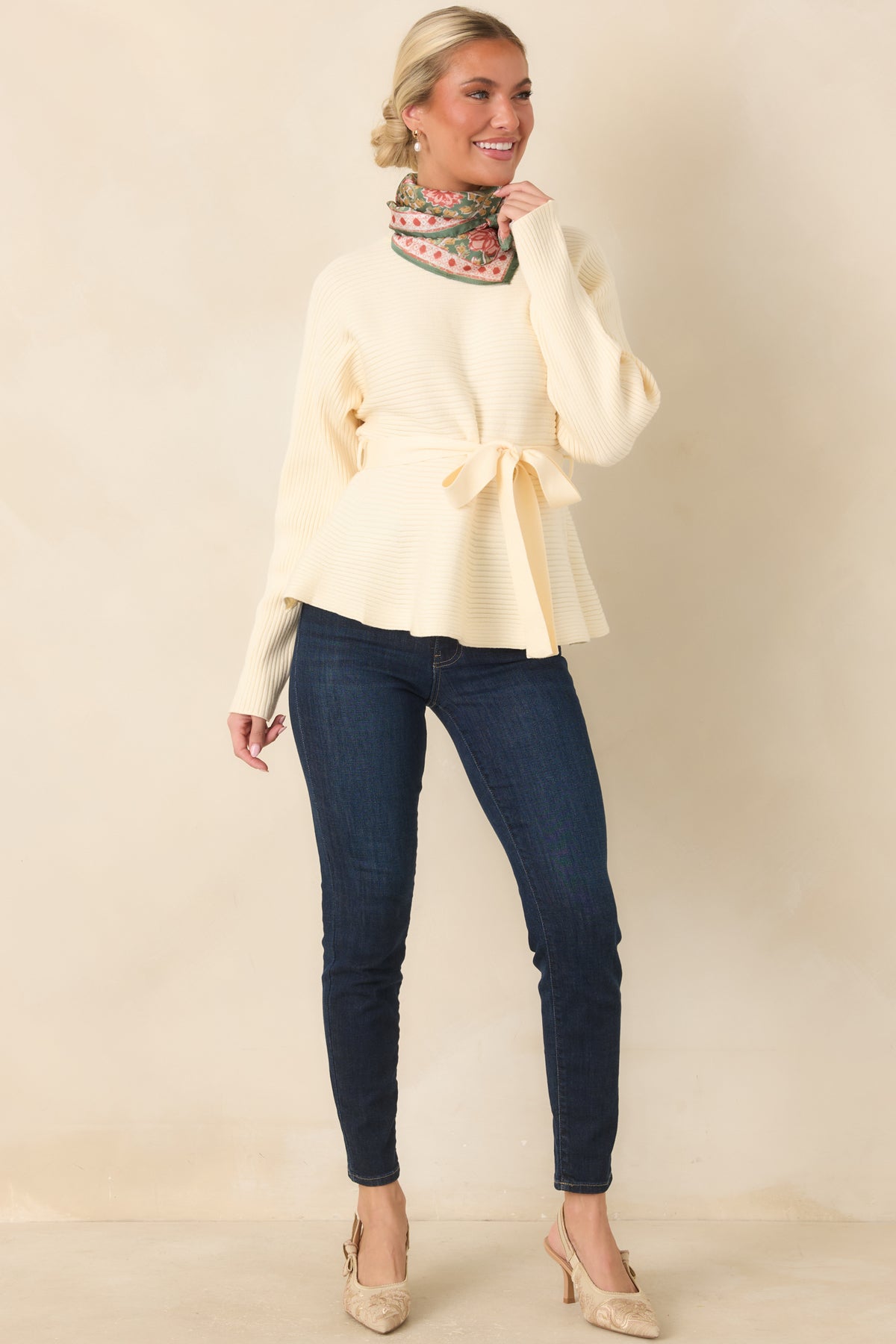 Ecru ribbed knit top with a mock neckline, long sleeves, and matching tie belt.