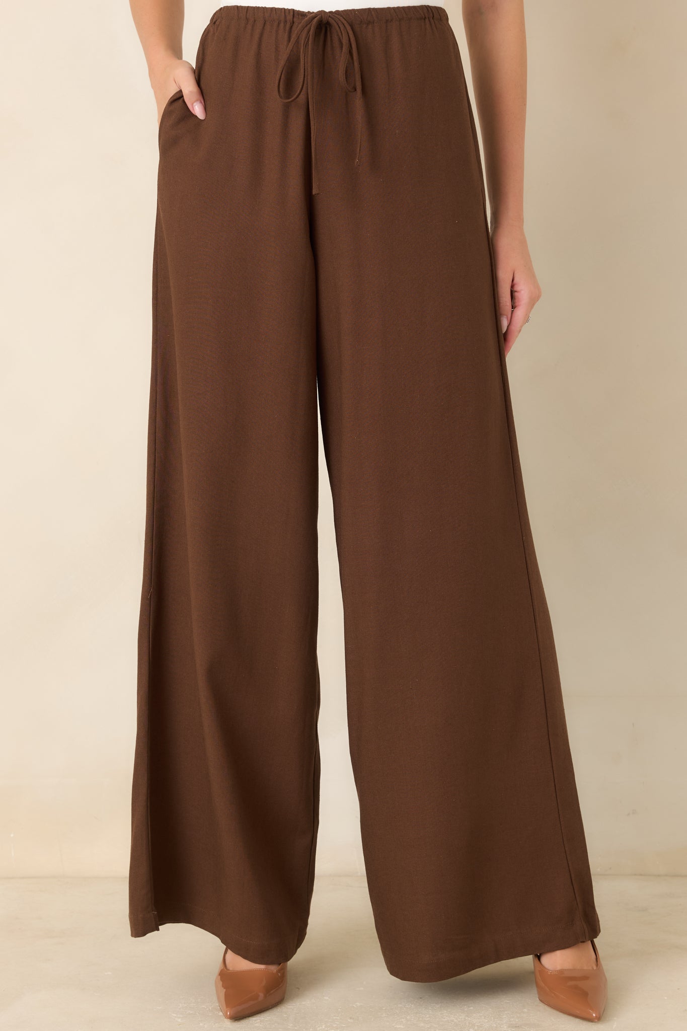 Detailed front view of the wide-leg pants showcasing the gathered elastic waist, decorative tie, and lightweight linen blend fabric.