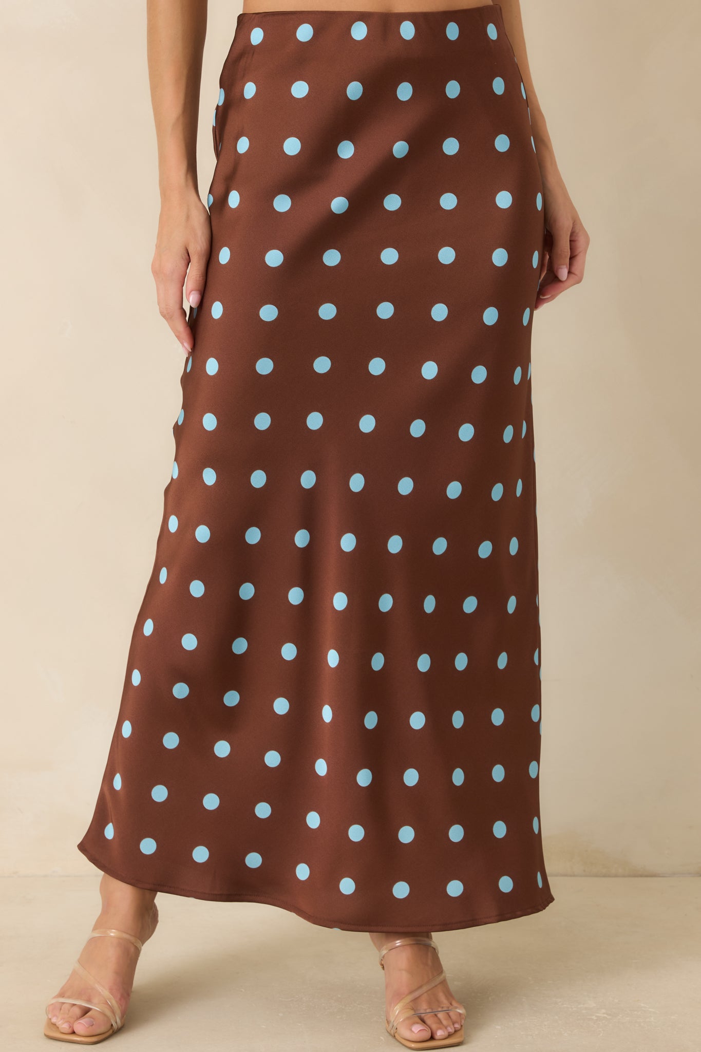 Detailed look at the skirt featuring the elastic waistband and silky satin fabric with vintage-inspired polka dots.
