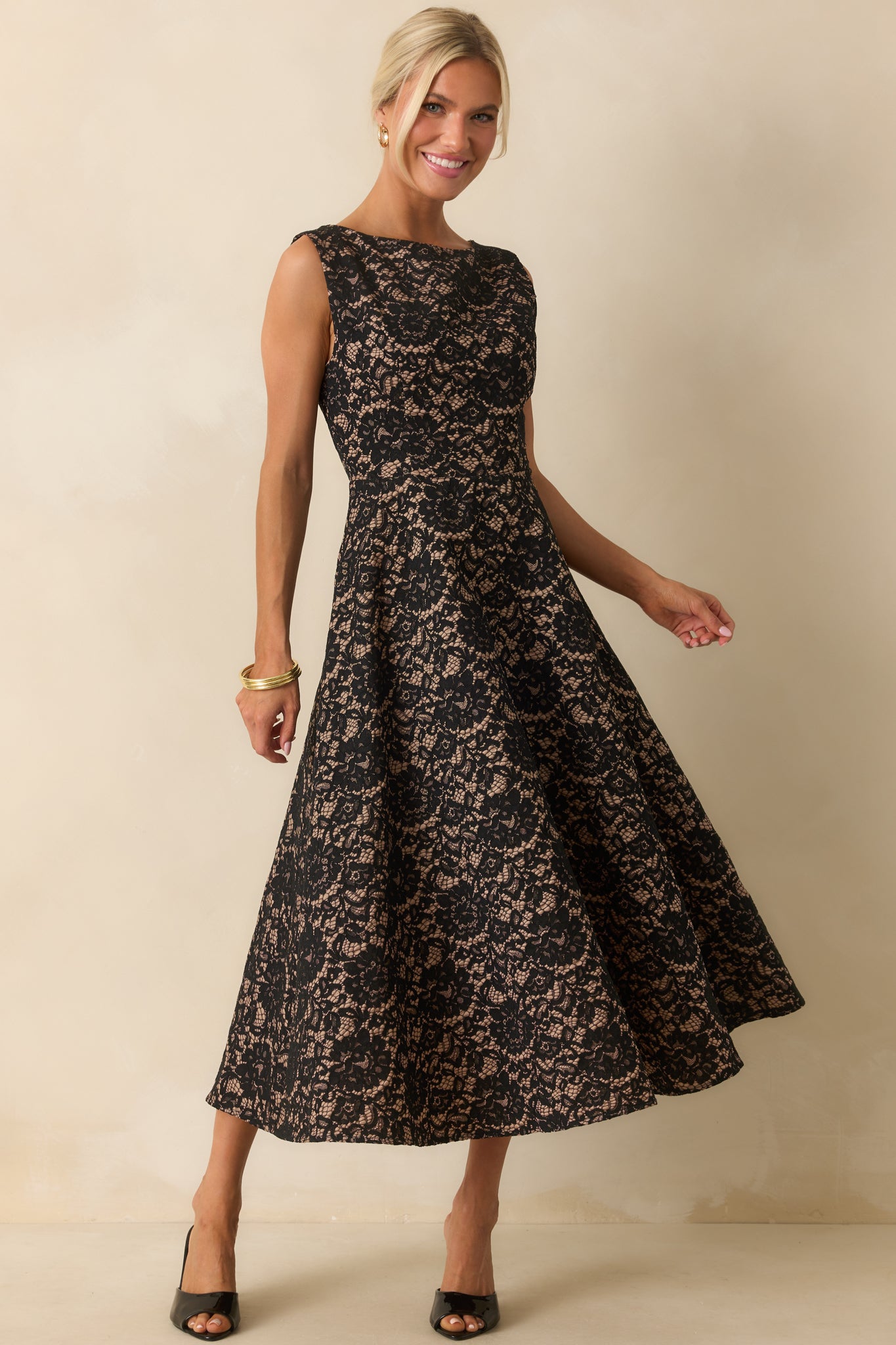 Elegant black lace dress featuring a round neckline and flared skirt for a timeless silhouette.