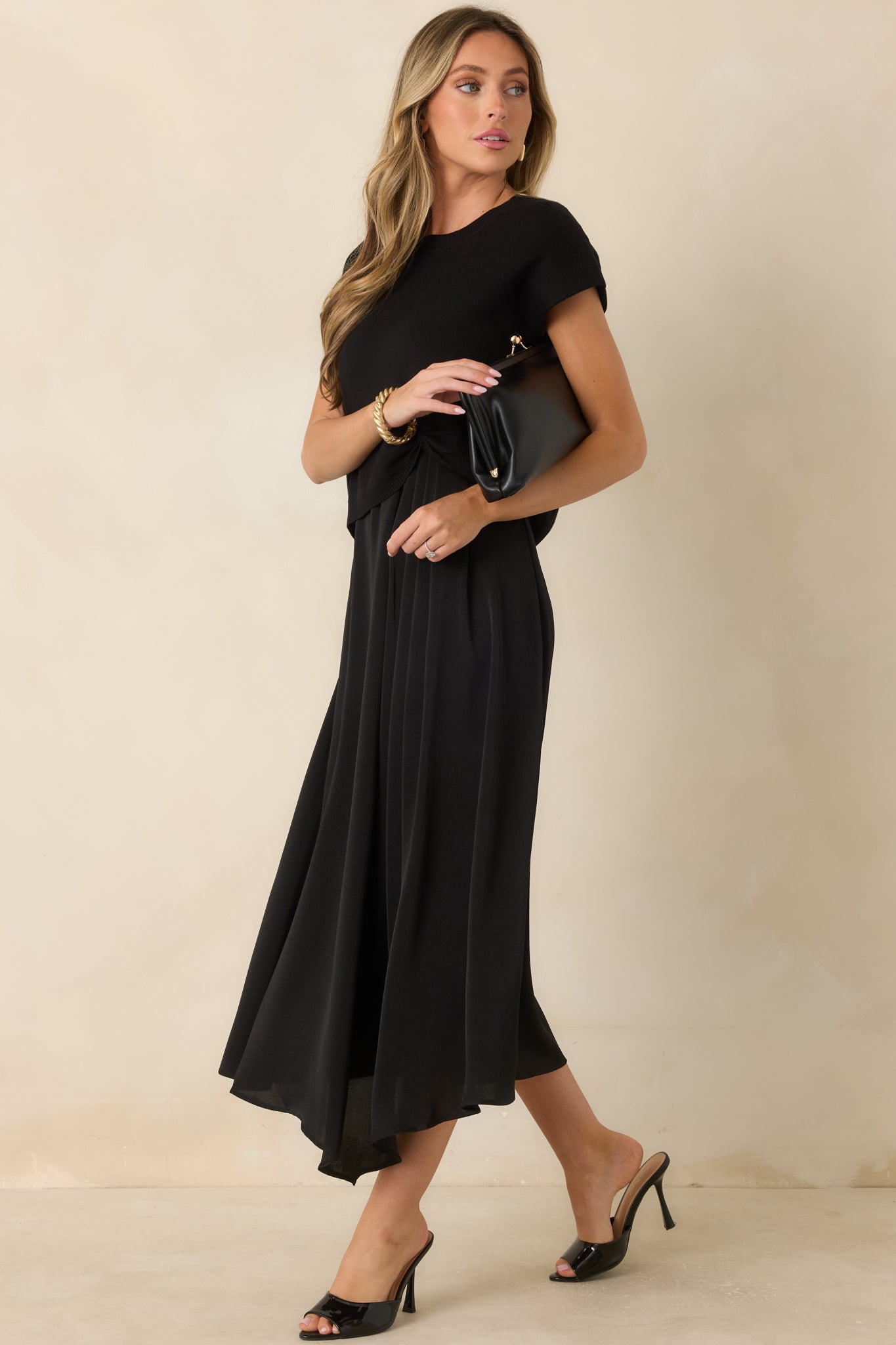 Elegant black midi dress showcasing a sleeveless silhouette, soft scoop neckline, and a fully lined satin skirt.