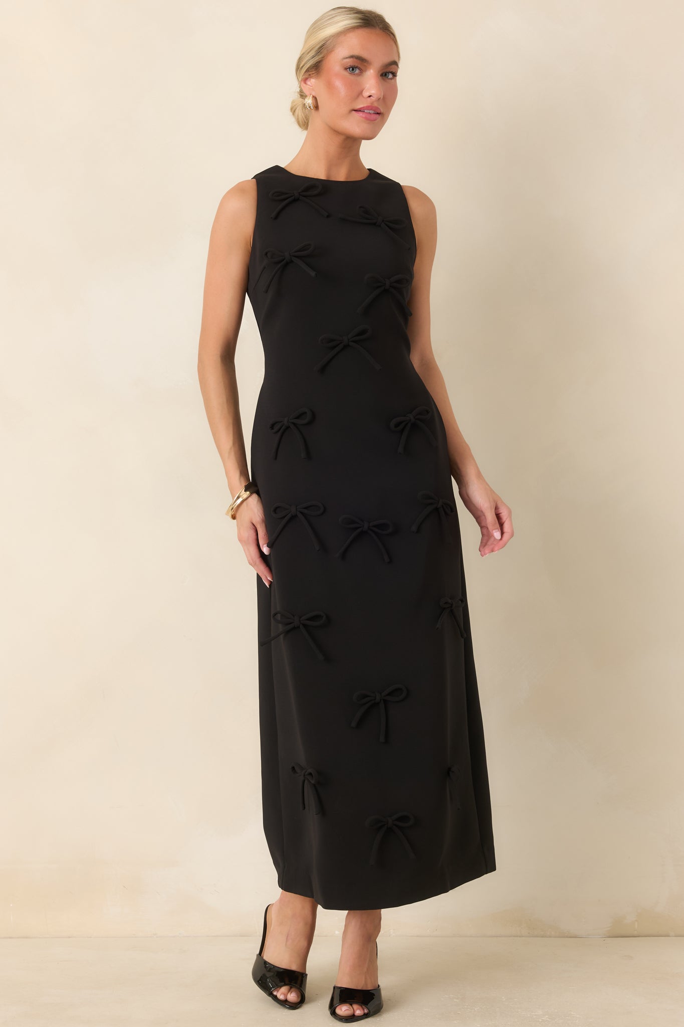 Elegant column maxi dress featuring a clean neckline, fitted shape, and allover three-dimensional bow texture.