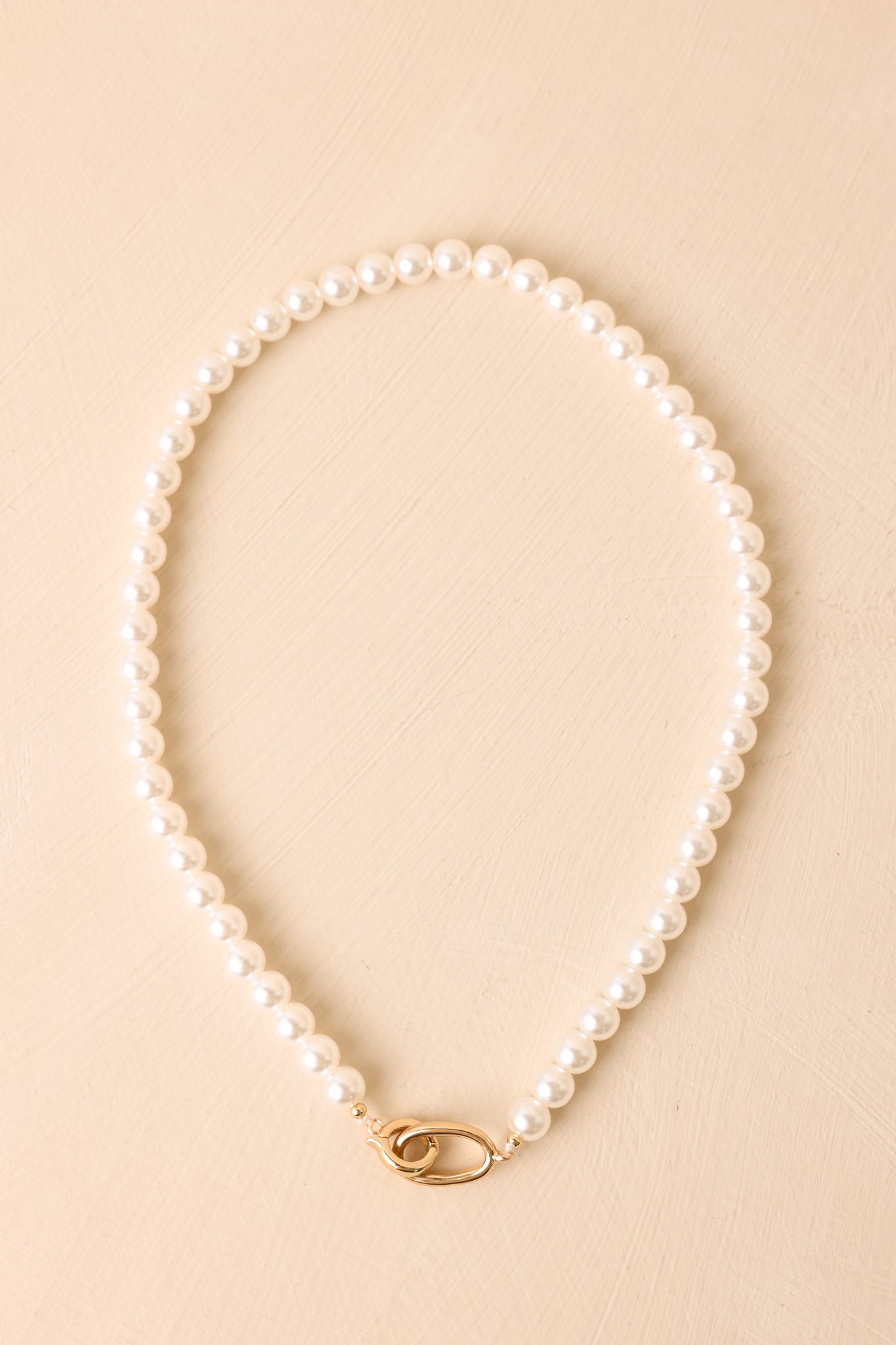 Elegant faux pearl necklace showcasing evenly sized lustrous pearls and a contemporary gold-tone hinged snap clasp.