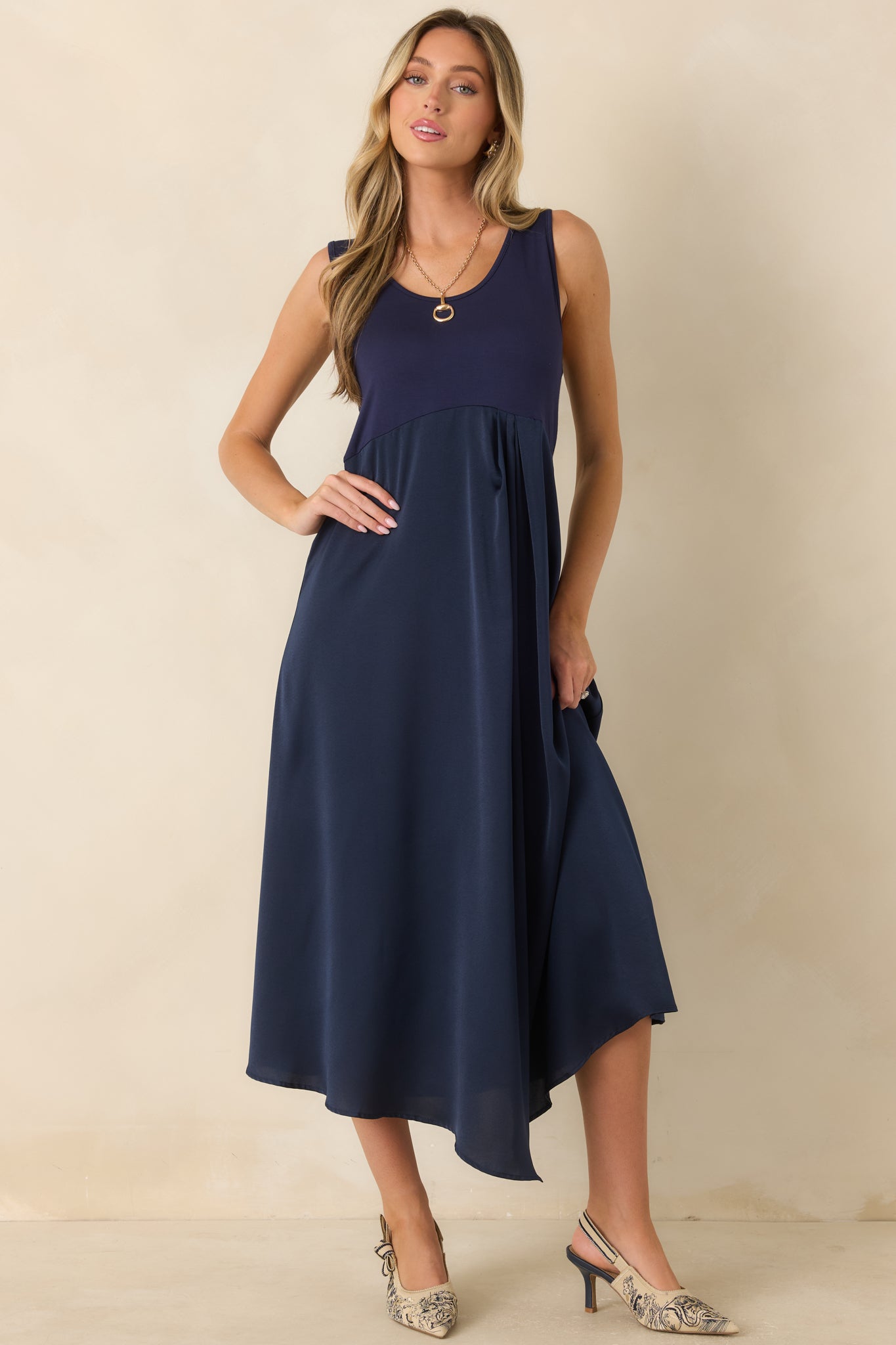Elegant sleeveless midi dress designed with a fitted knit bodice and a flowing satin skirt for a polished silhouette.