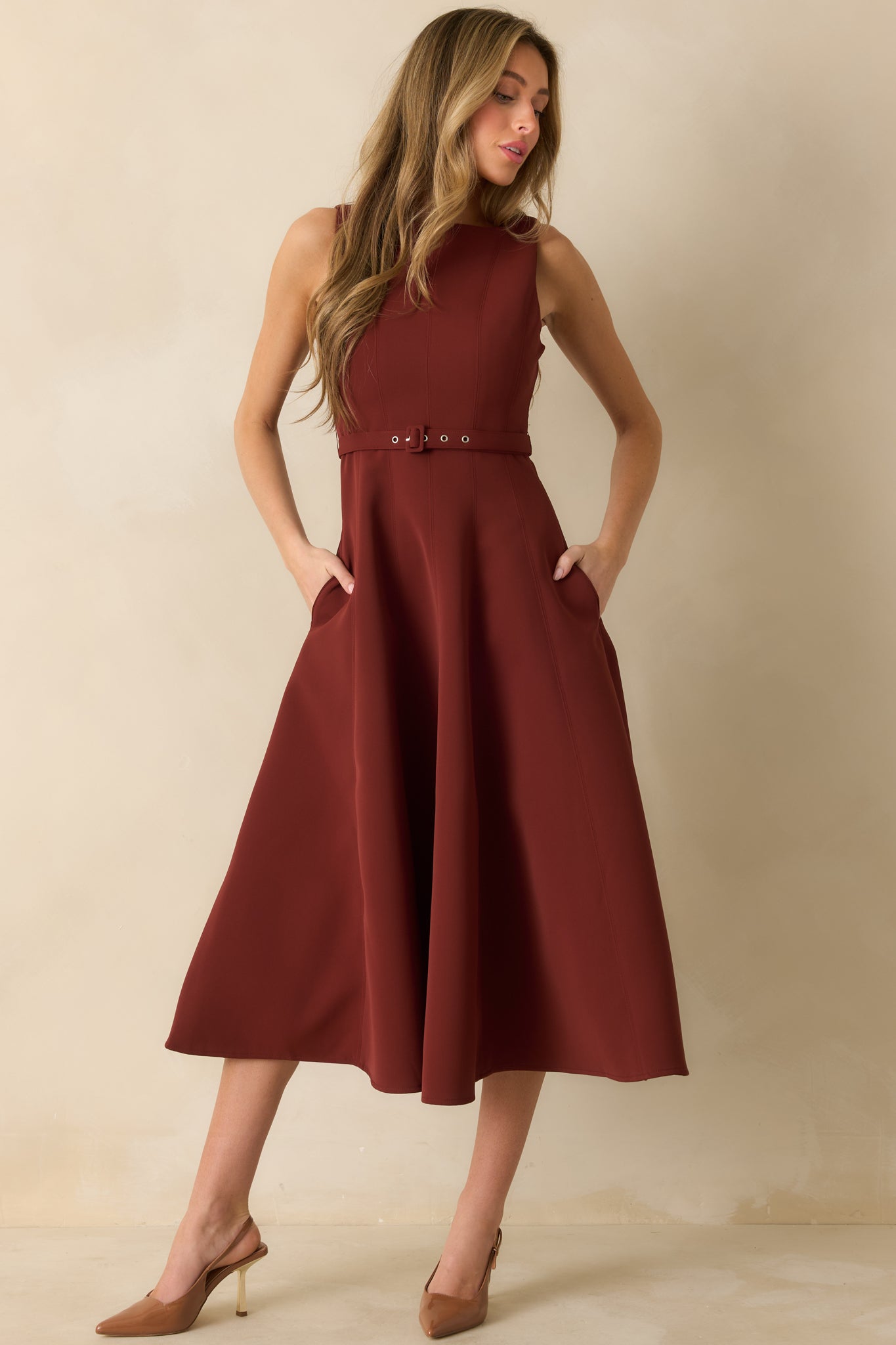 Elegant sleeveless midi dress in red highlighting a defined waist and A-line flare.