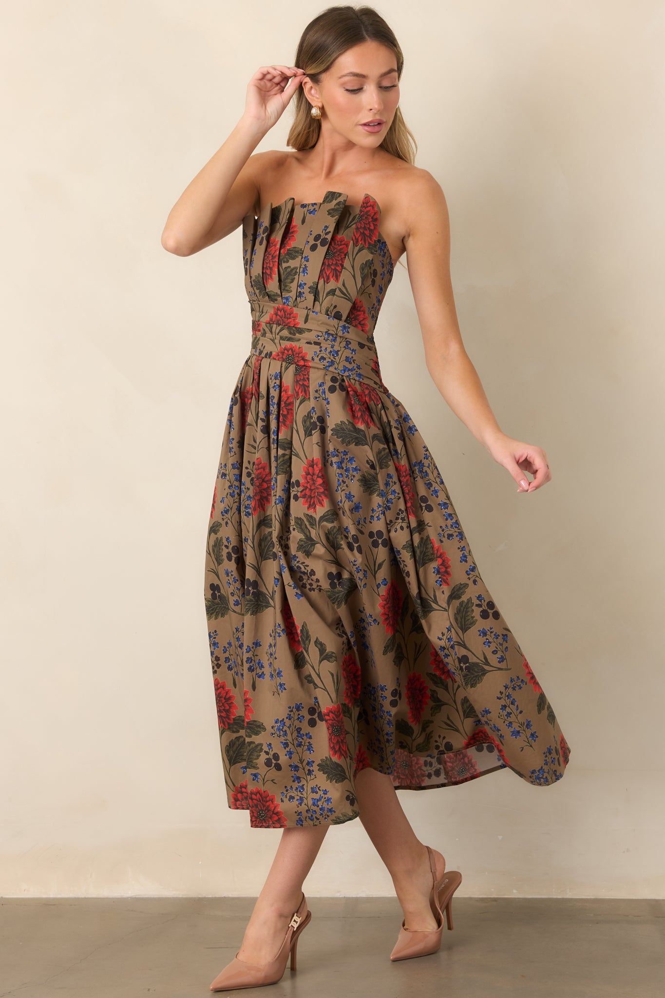 Elegant strapless midi dress with a defined waist and expansive floral skirt combining red blooms, cobalt flowers, and deep olive leaves.