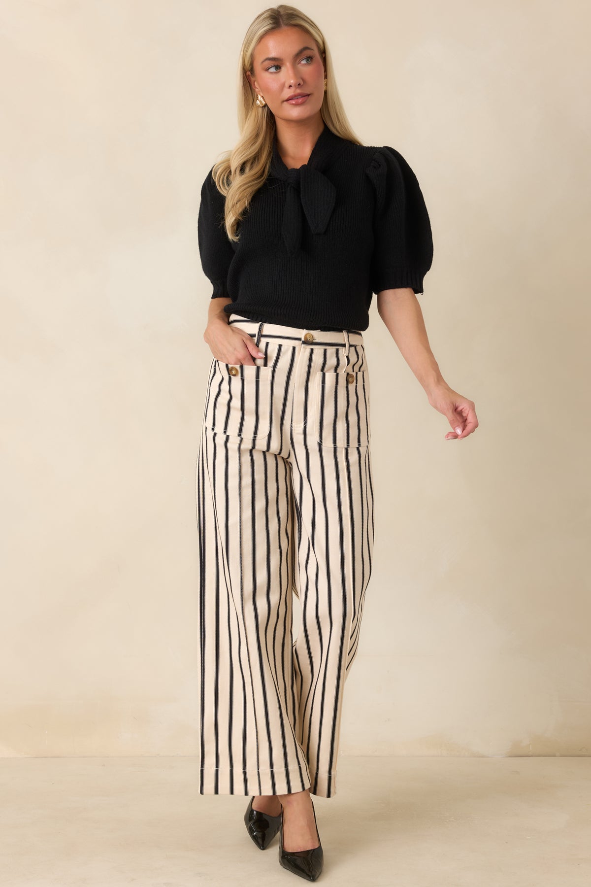 Elegant sweater top designed with a statement bow neckline, long puff sleeves, and a flattering fitted shape.