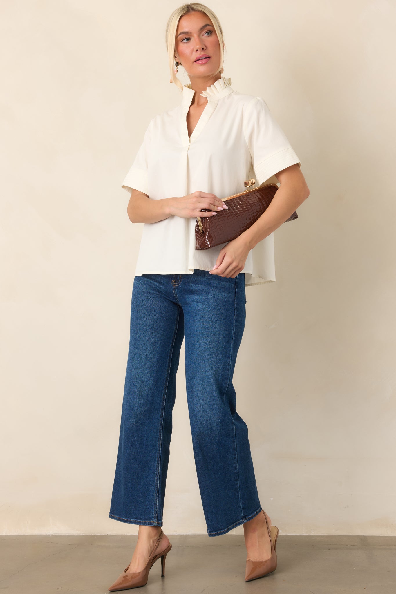 Elevated cotton top with layered pleats around the collar, a relaxed split neckline, and short sleeves accented by subtle stitched cuffs.