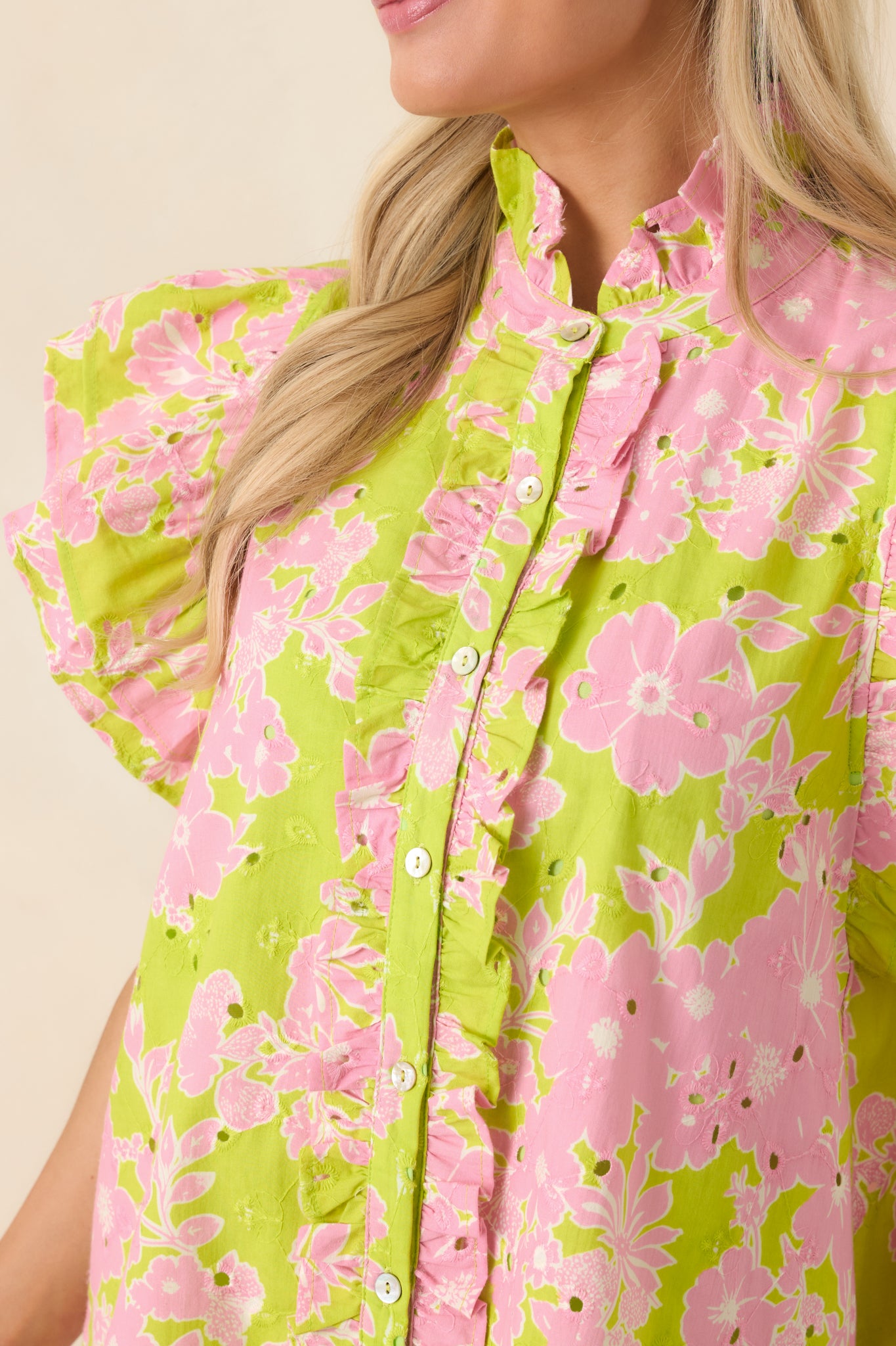 Embroidered eyelet fabric with floral pattern and ruffle trim detail.