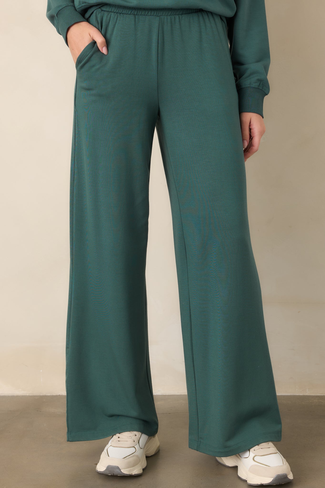 Close view of the emerald green pants highlighting the elastic waistband and smooth modal stretch fabric.