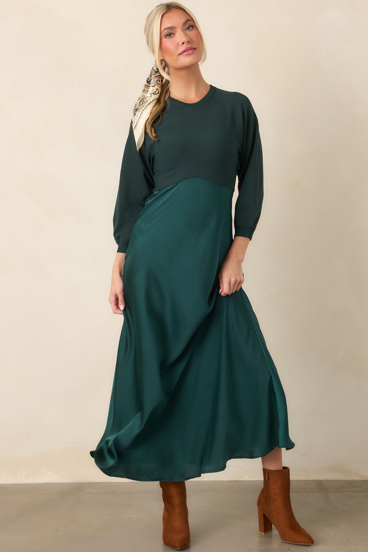 Coordinated-look midi dress combining a fitted emerald knit top with a high-waisted satin skirt in a softly flowing silhouette.