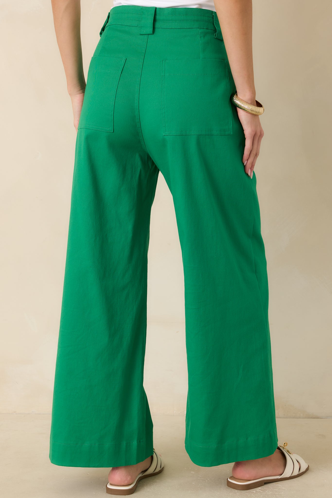 Back view of emerald wide leg pants featuring patch pockets, relaxed fit, and flowing wide hem.