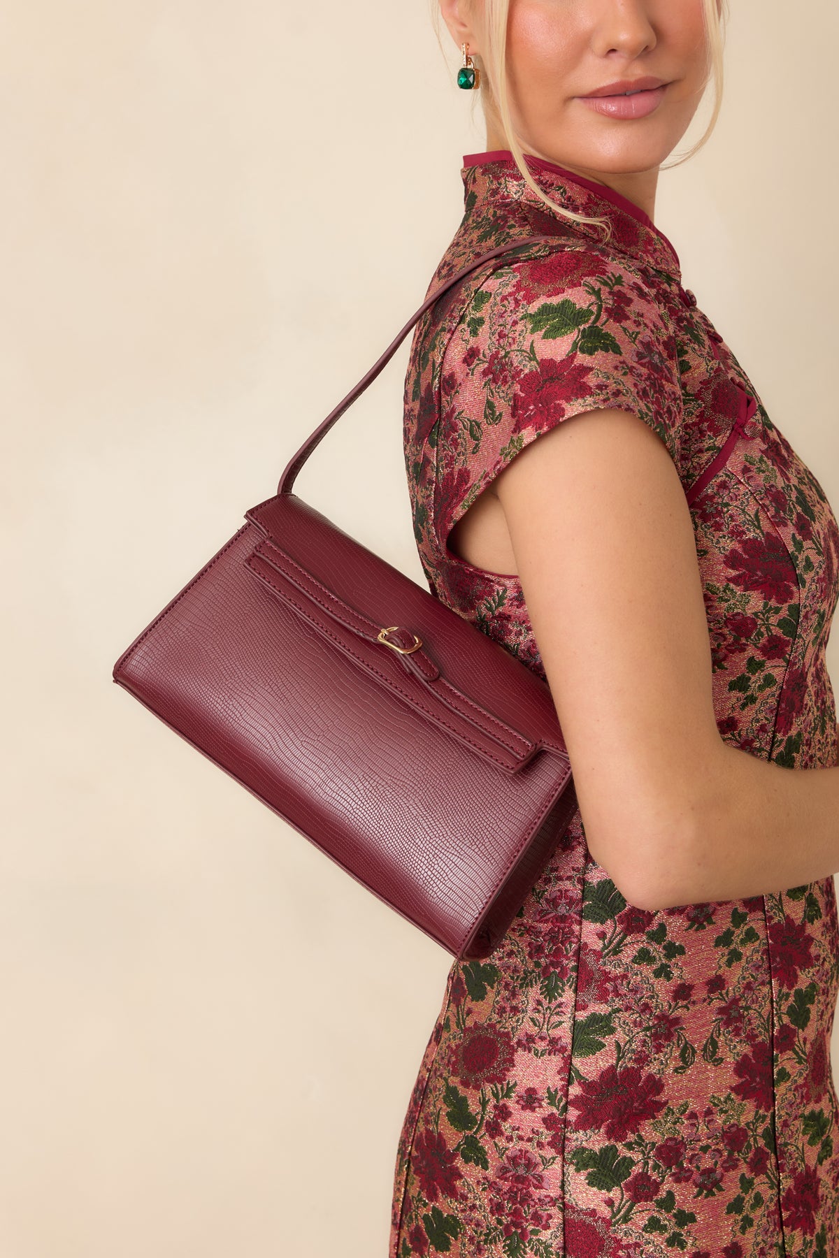 Envelope-style handbag features a clean flap closure accented by a dainty gold-tone buckle and subtle textured detailing.