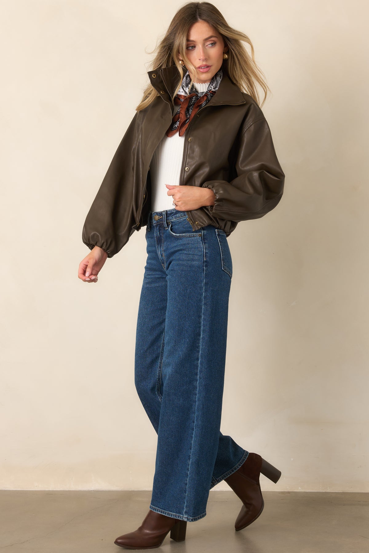 Espresso faux leather jacket features dramatic balloon sleeves, a high stand collar, and antique gold-tone hardware.